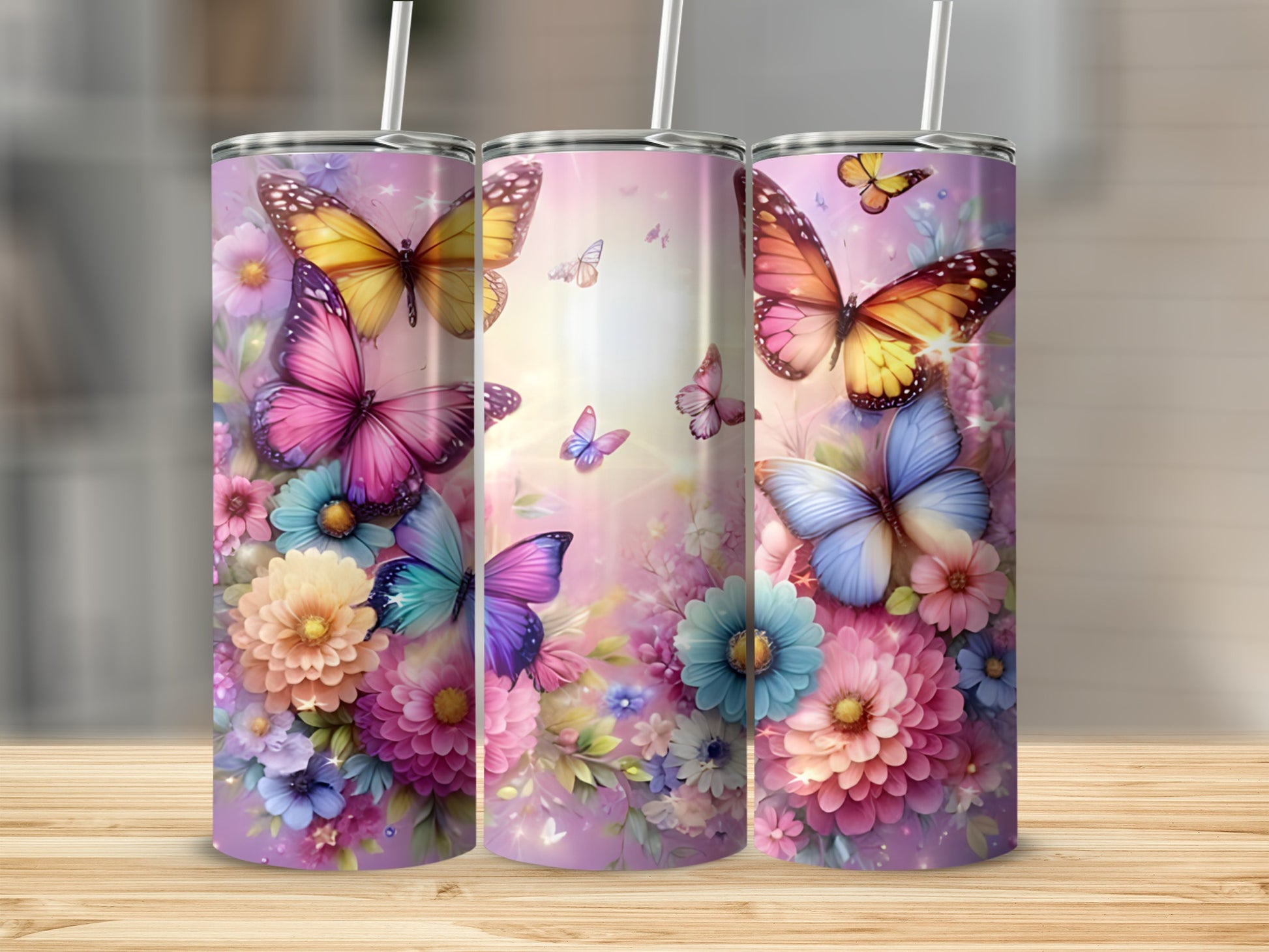 Three tall tumblers adorned with colorful butterflies and flowers.