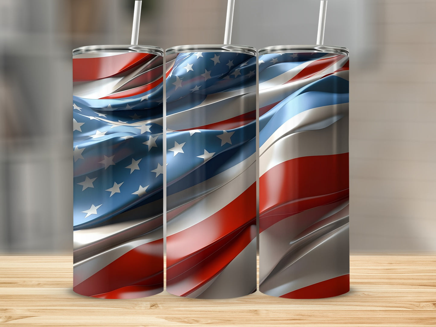 Three tumblers with a flowing American flag design stand on a wooden surface.