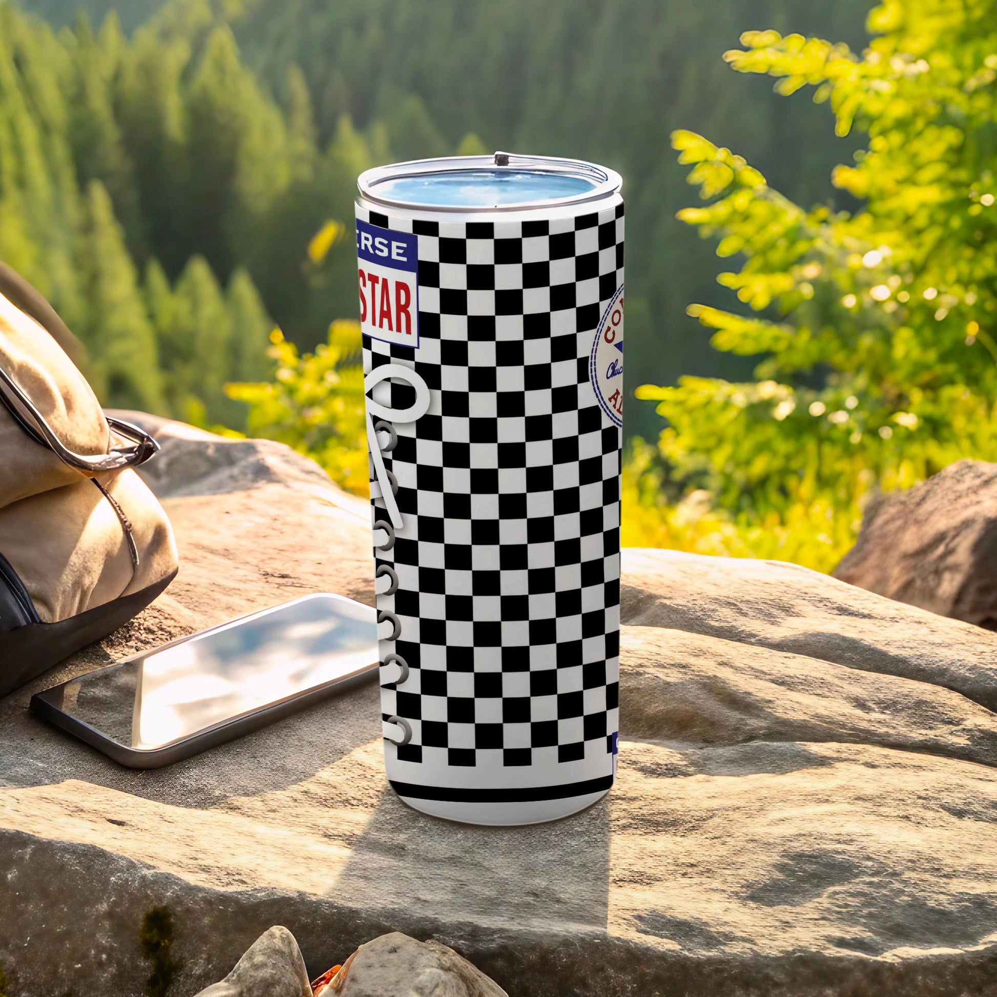 Black and white checkered Converse tumbler with a backpack and phone.