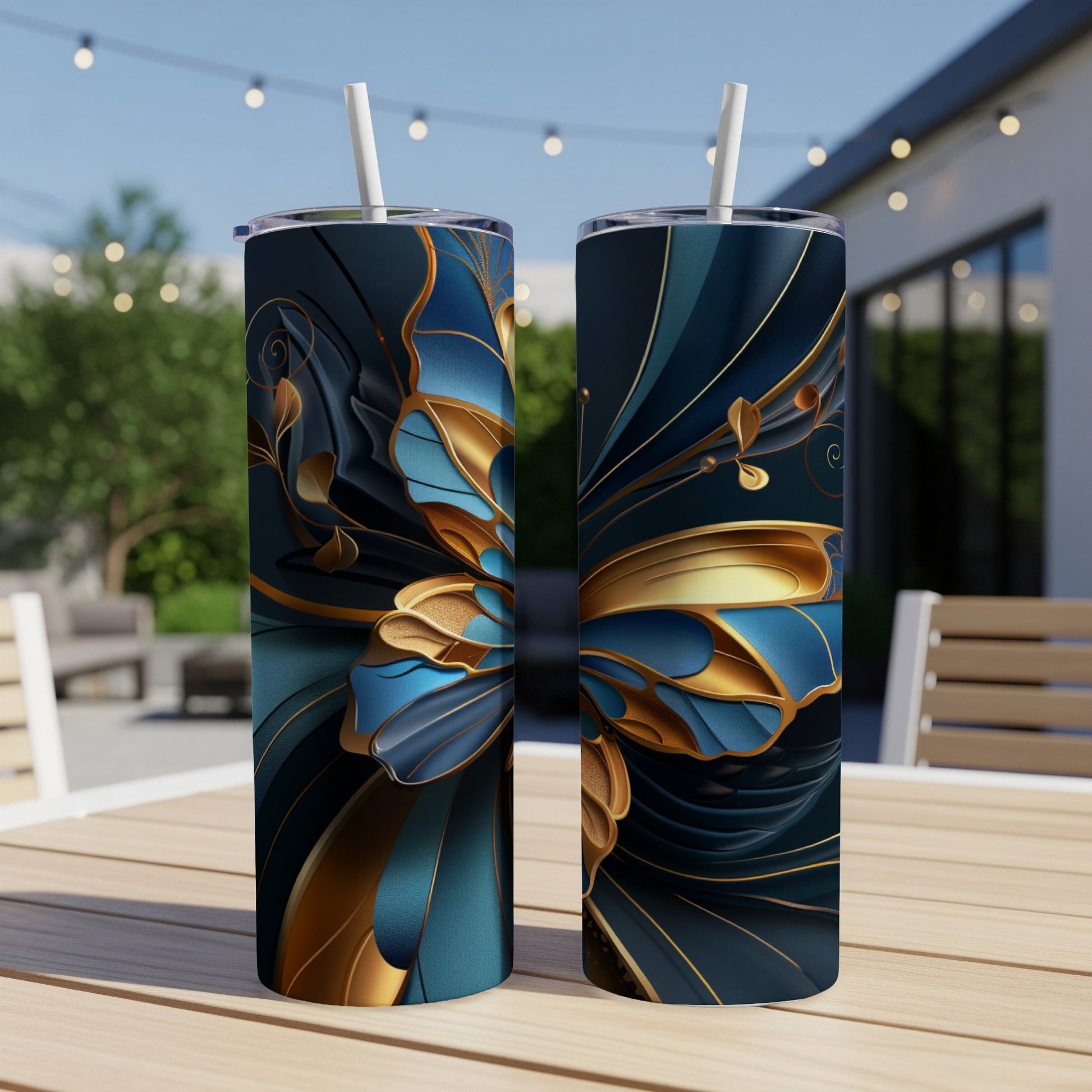 Two tall tumblers with blue and gold floral abstract design on outdoor table.