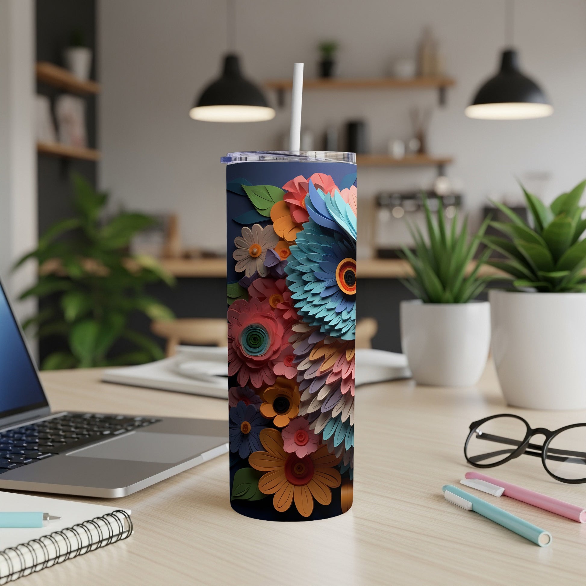 Colorful owl design on a dark blue tumbler with a straw, resting on a desk.
