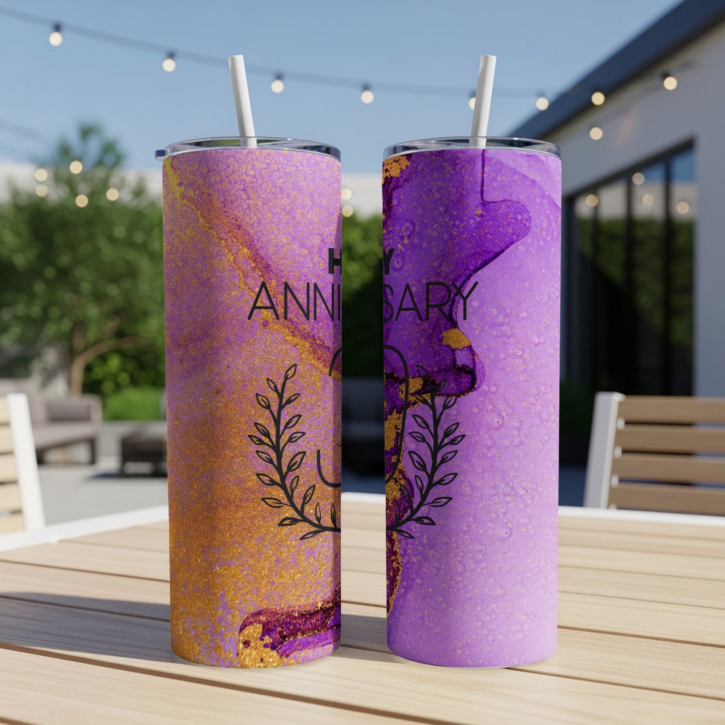 Two tumblers with "Happy Anniversary" text and floral design on a wooden table.