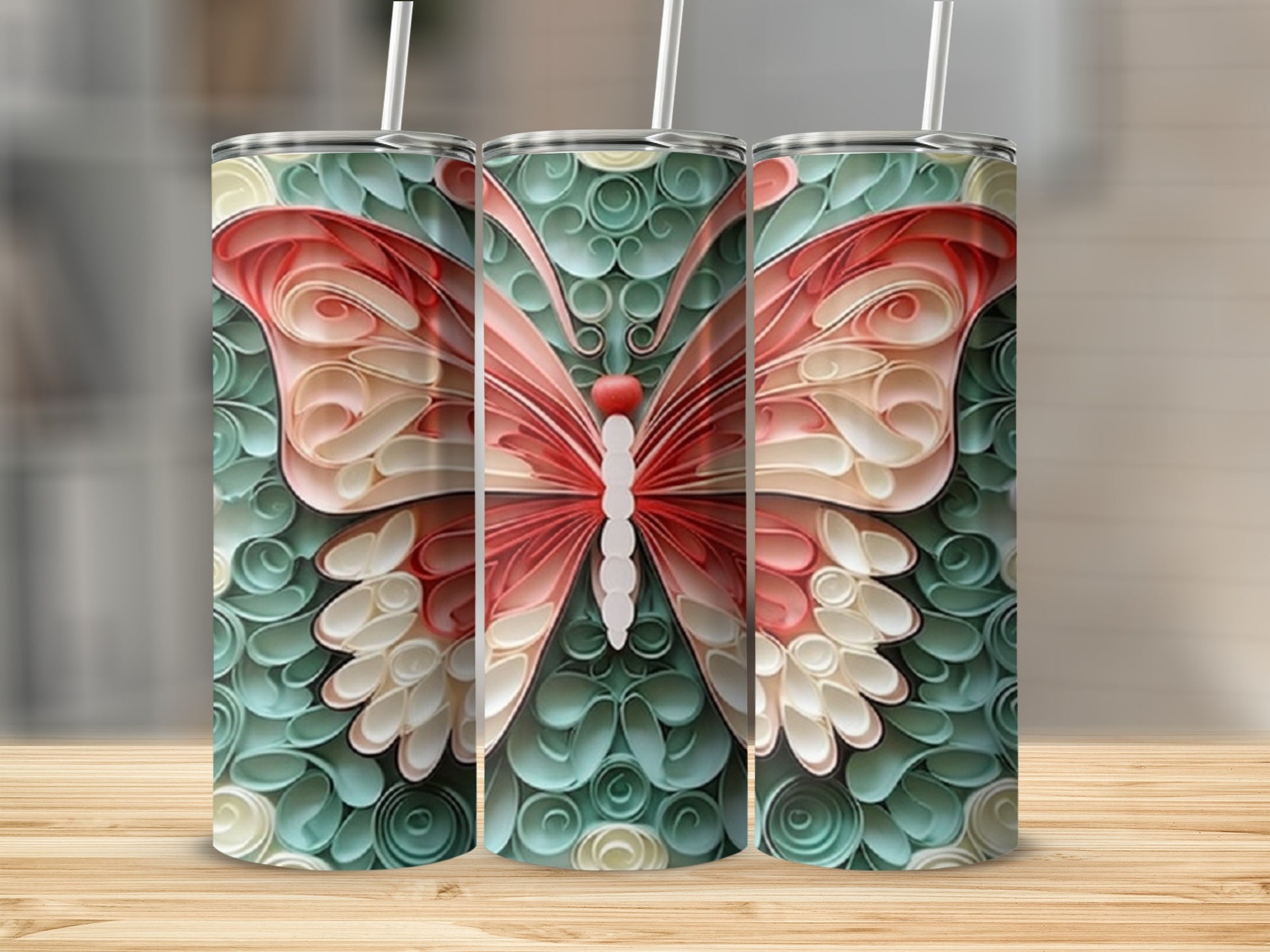 Three tumblers with a pink and cream butterfly design on a teal background.