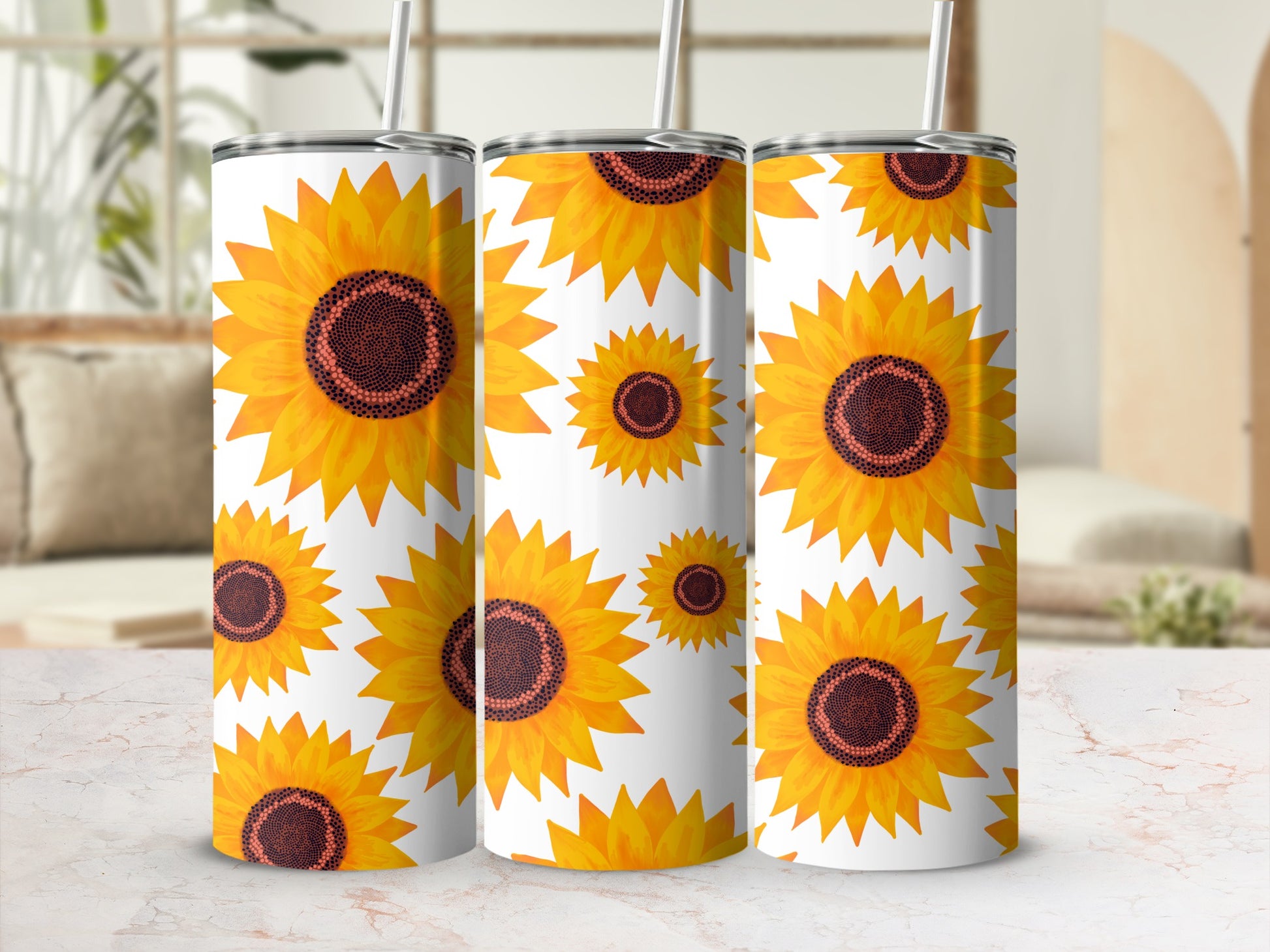 Three tumblers with a repeating sunflower pattern on a light marble surface.