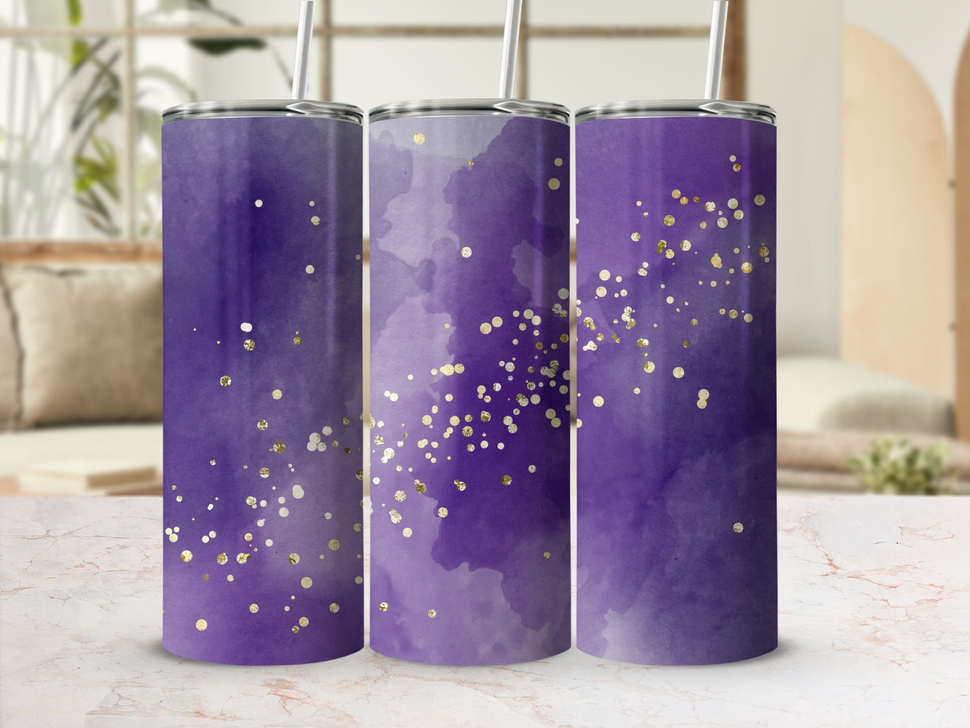 Three purple tumblers with gold glitter accents and straws.