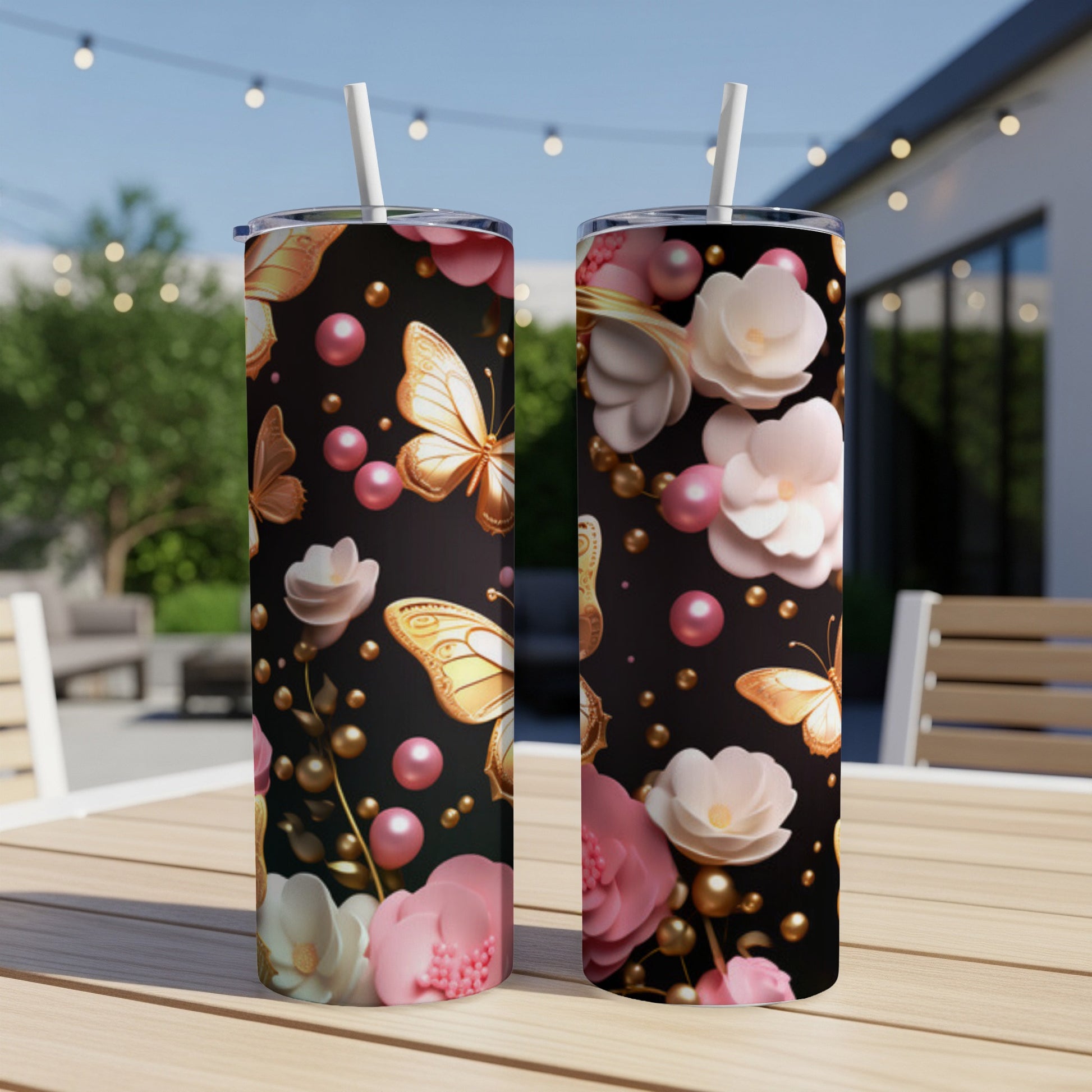 Two tumblers with gold butterflies and pink flowers on a black background.