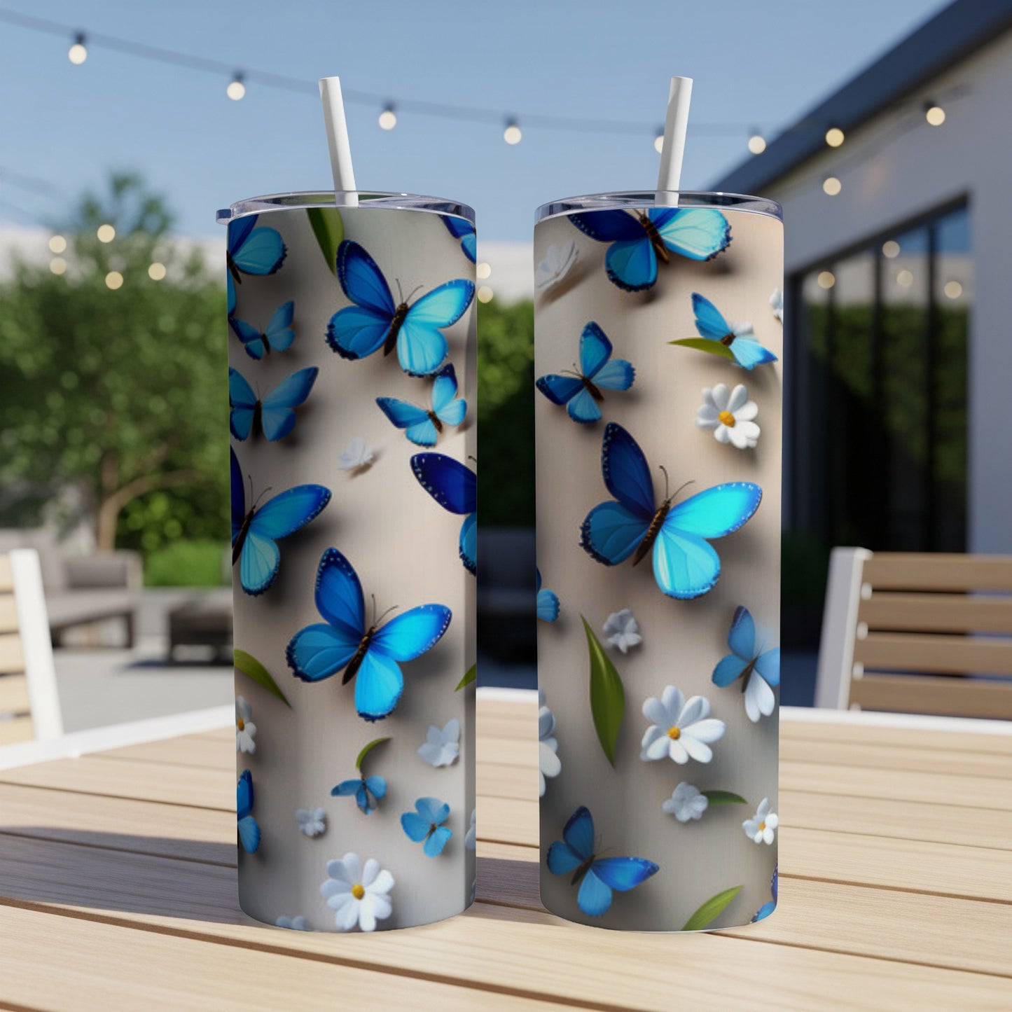 Two tall tumblers with blue butterflies and white flowers on a light background.