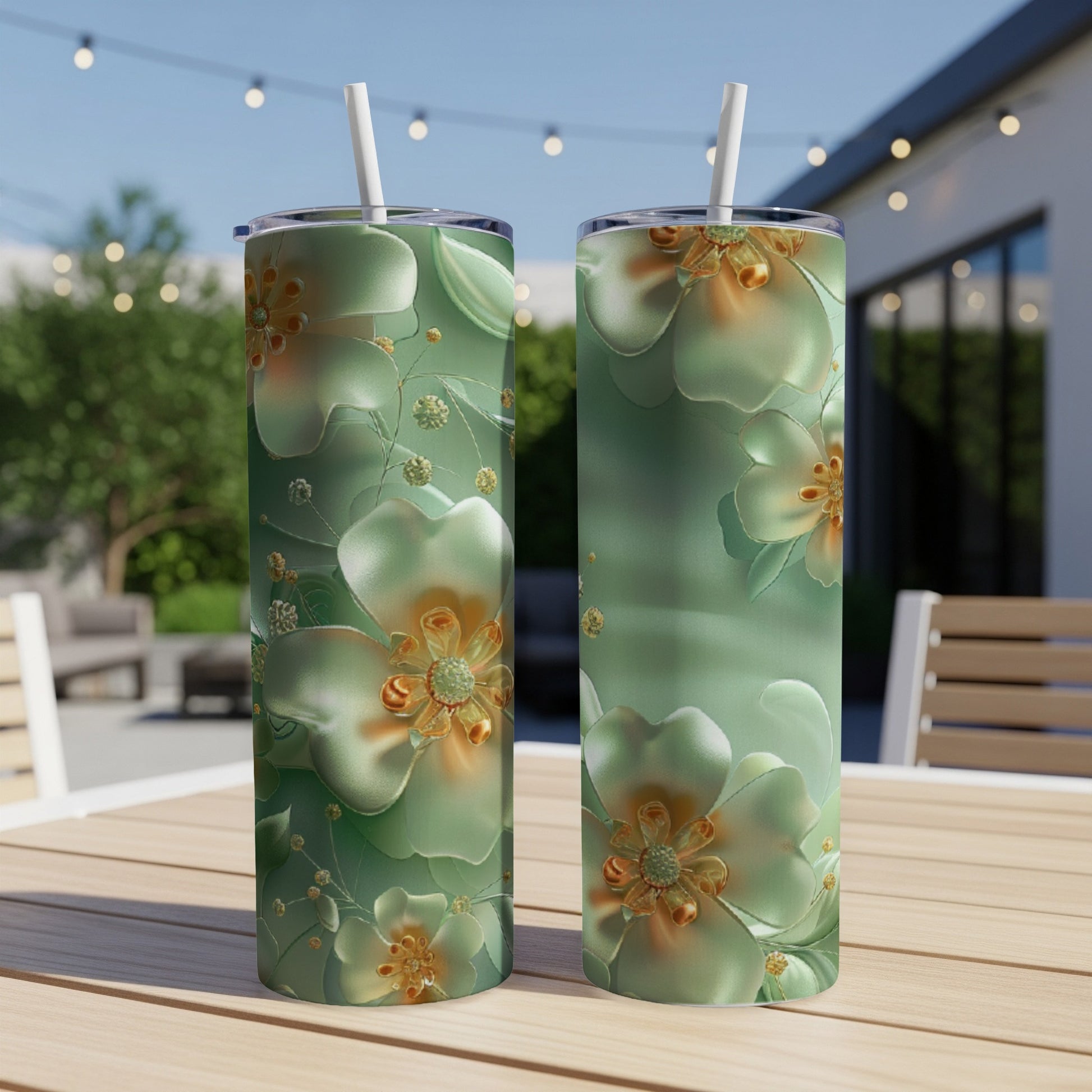 Two tall green tumblers with floral designs and gold accents sit on a wooden table.