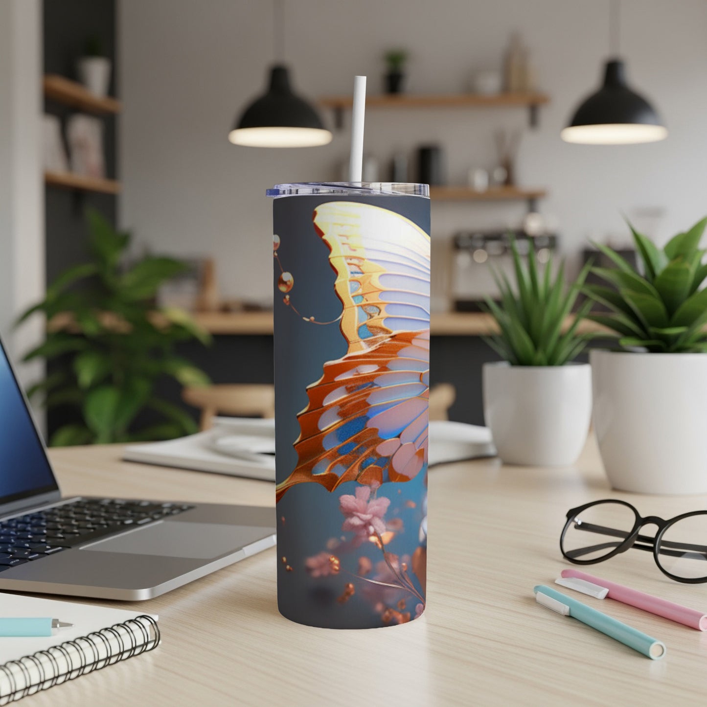 Butterfly design on a white tumbler with a straw, on a desk.