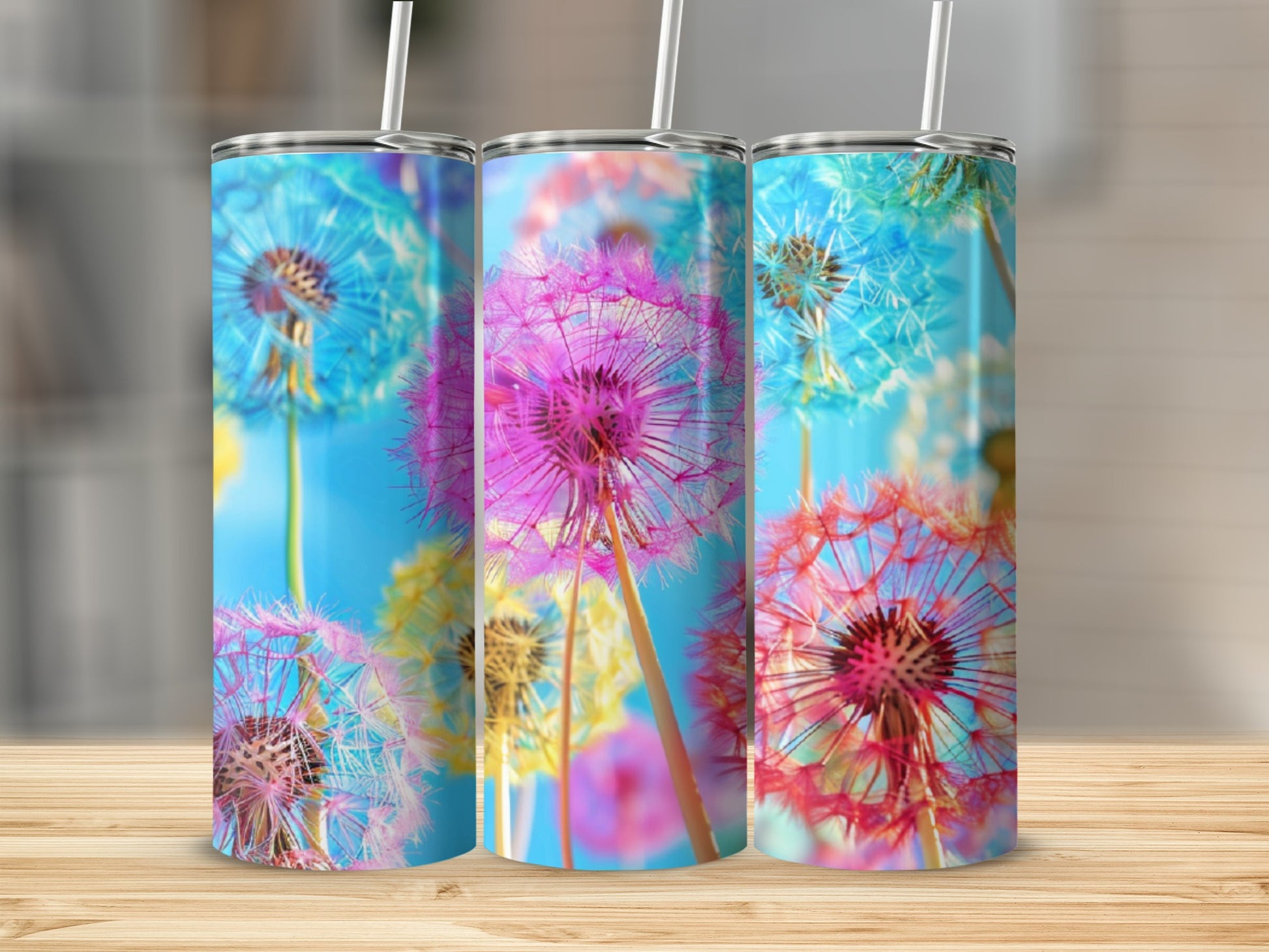 Three tumblers with dandelion graphics in blue, pink, and yellow.