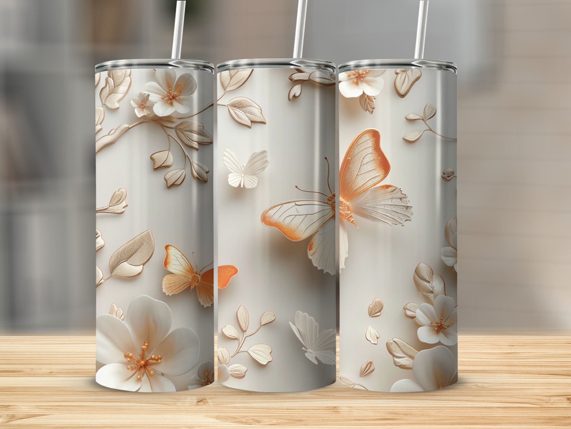 Three tall tumblers with embossed white flowers and orange butterflies.