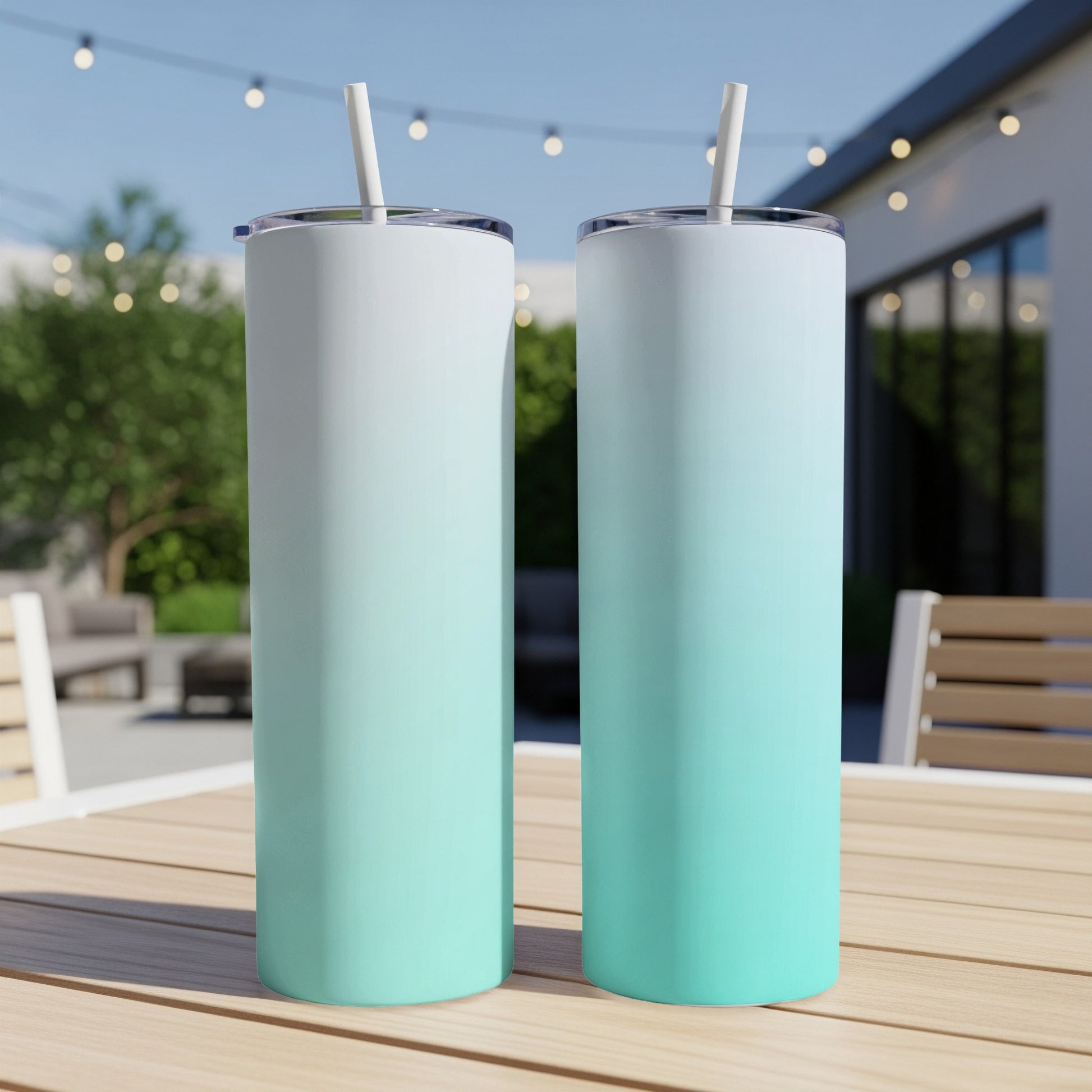 Two tumblers with a teal to white gradient stand on a wooden table.