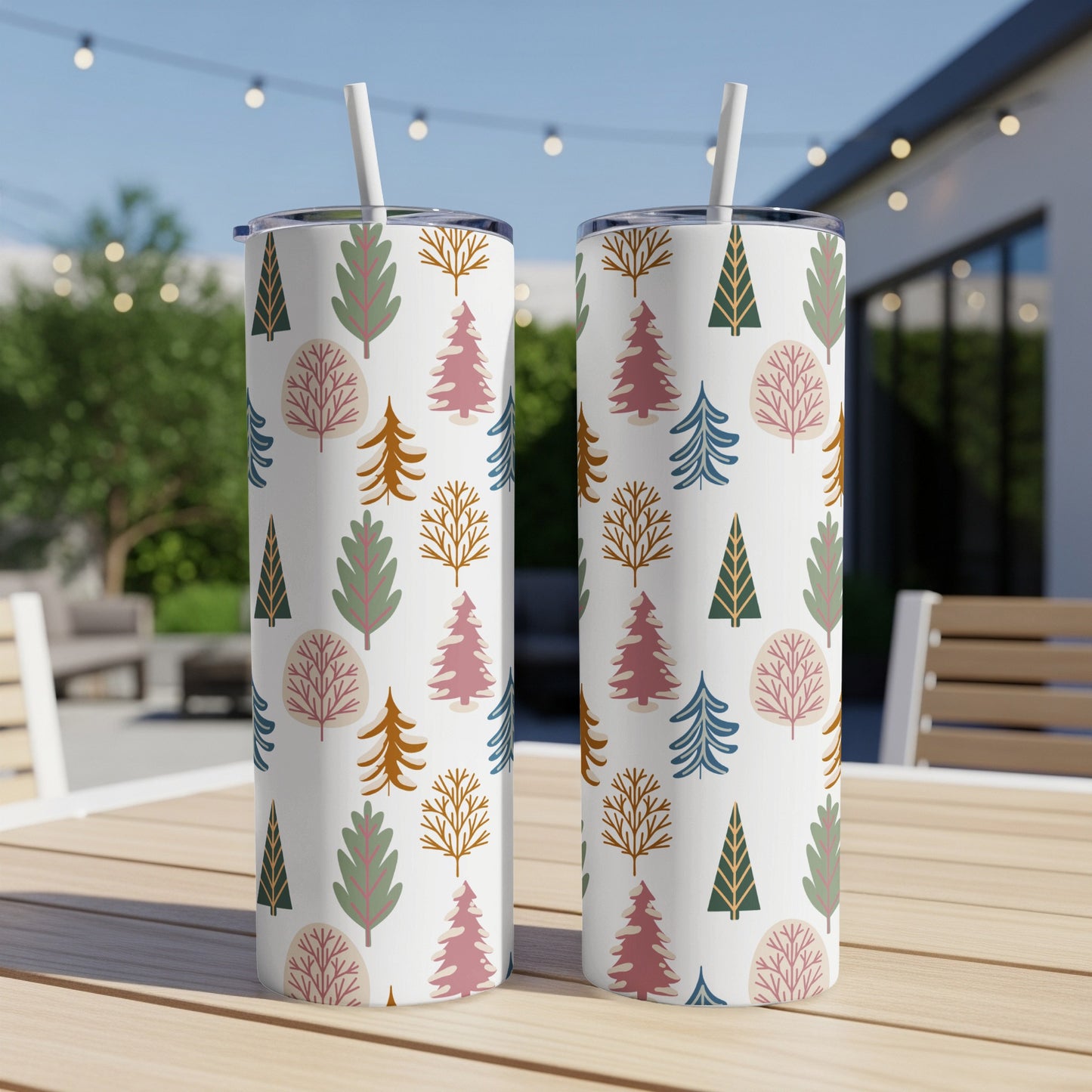 Two tumblers with a repeating pattern of stylized trees on a wooden table.