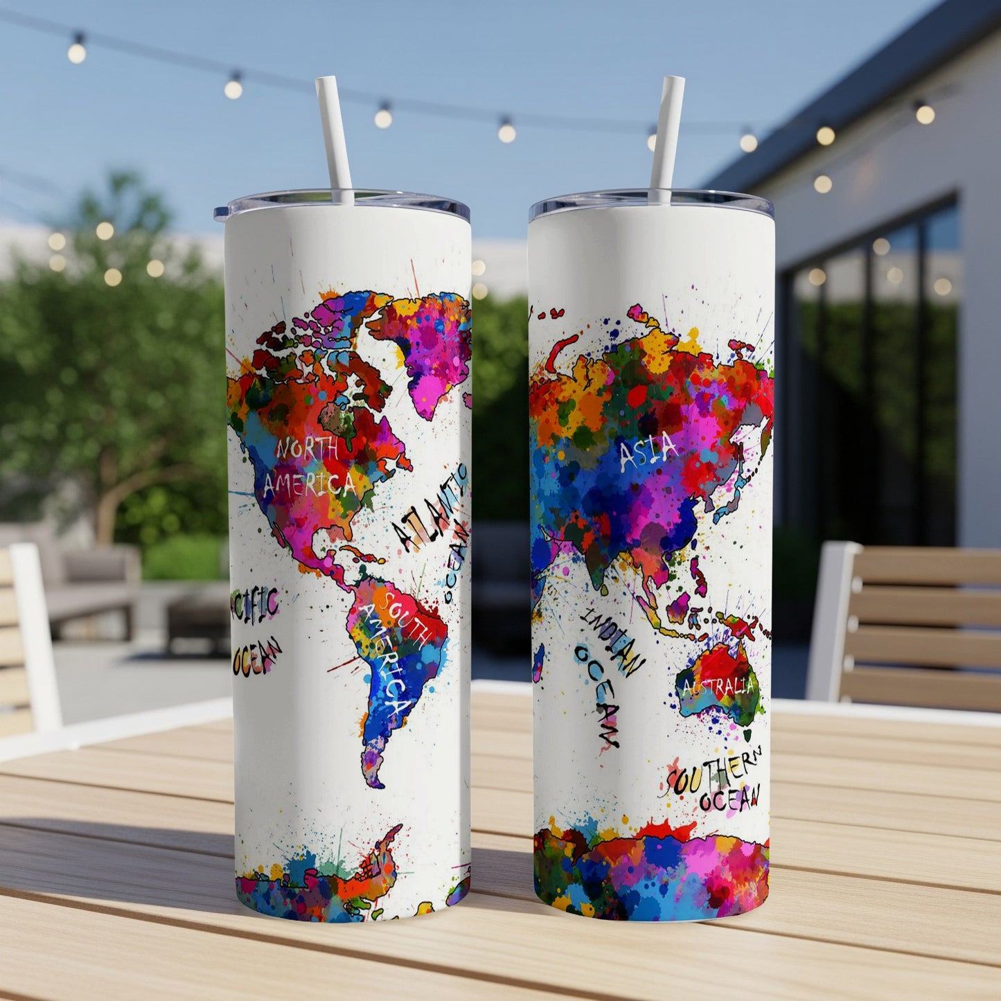 Two skinny tumblers with a colorful, artistic world map design and straws.