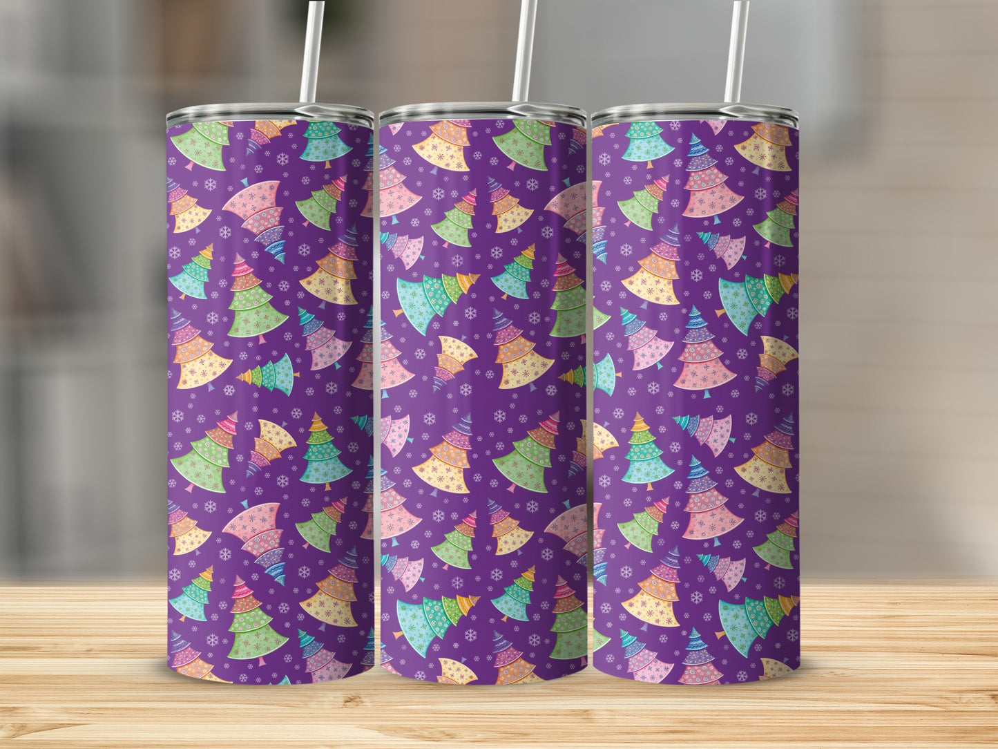 Three purple tumblers with colorful Christmas tree pattern and snowflakes.