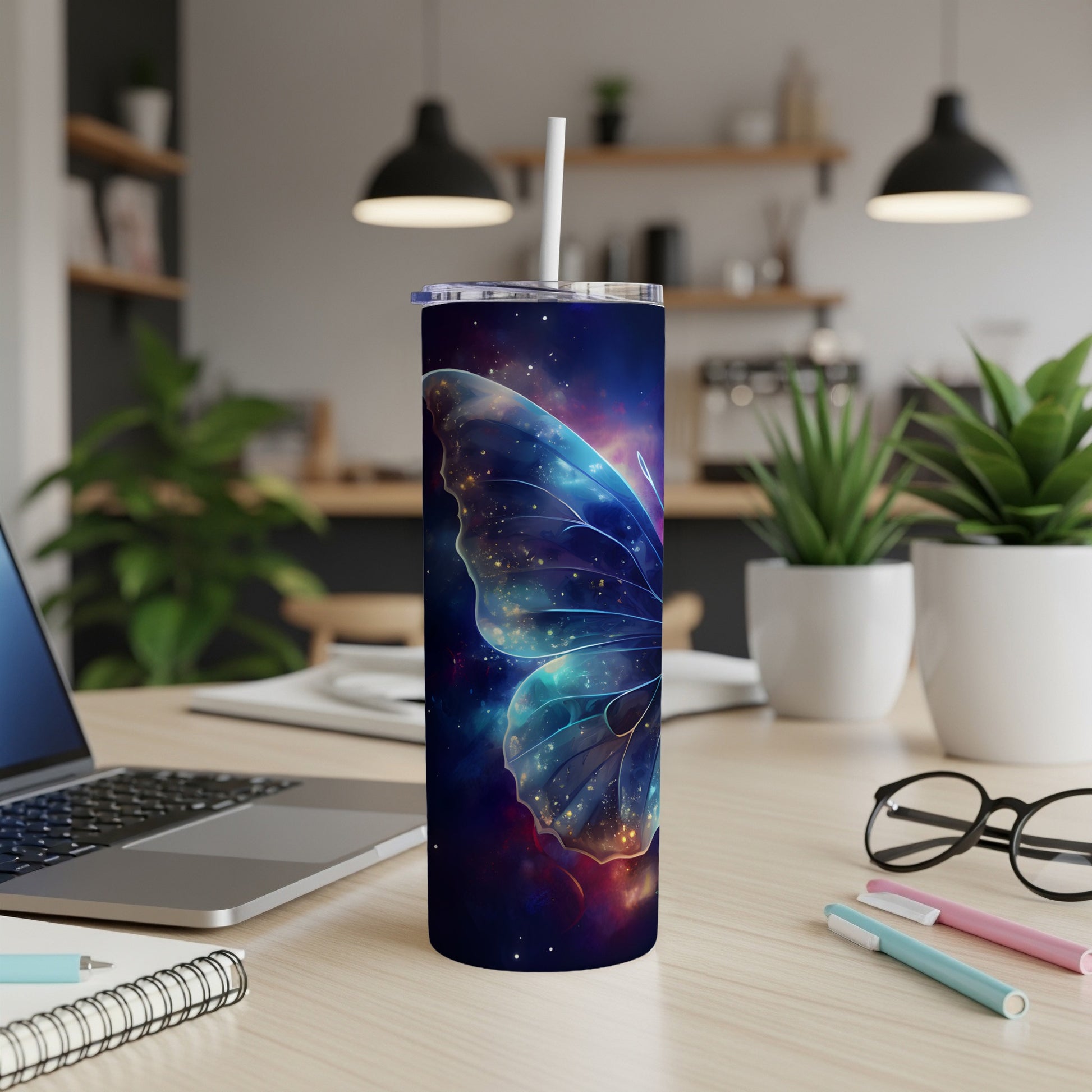 Cosmic butterfly wing design on a white tumbler with straw.