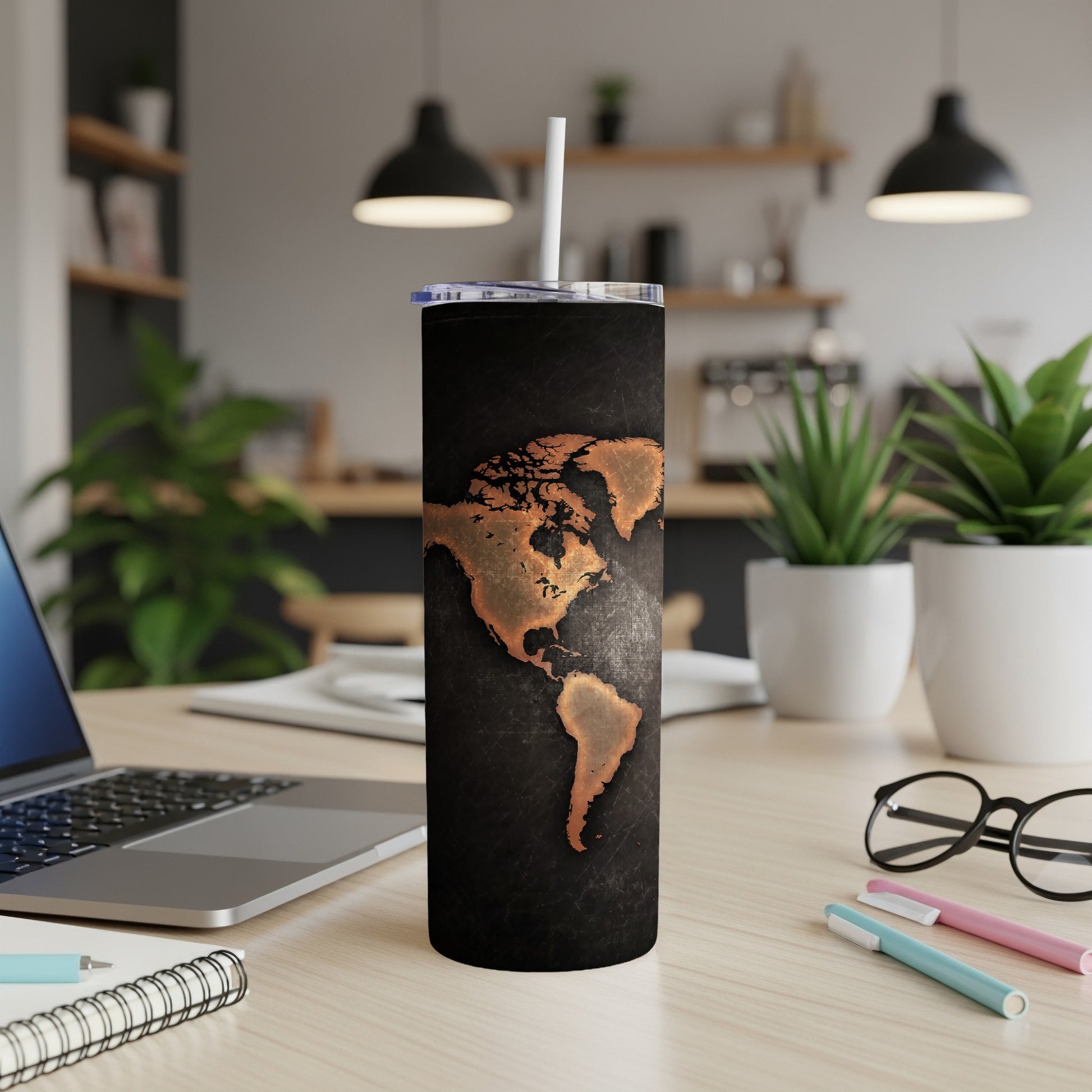 Black tumbler with copper map of North and South America and a white straw.