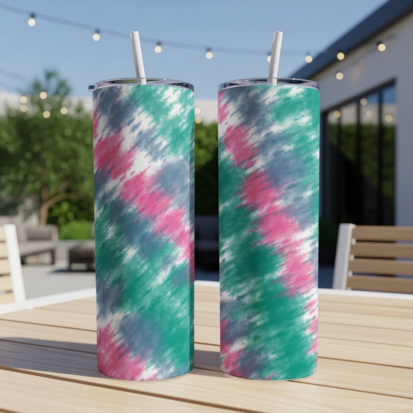 Two tumblers with pink, teal, gray, and white tie-dye pattern on a table.