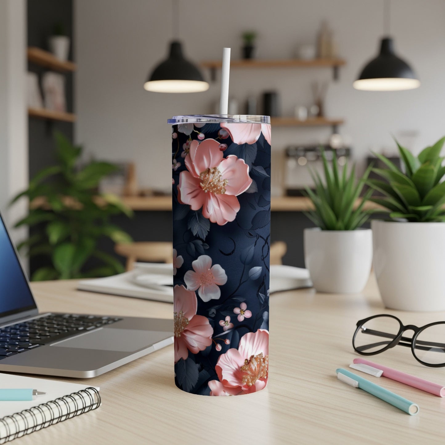 Floral patterned tumbler with a straw on a wooden desk.
