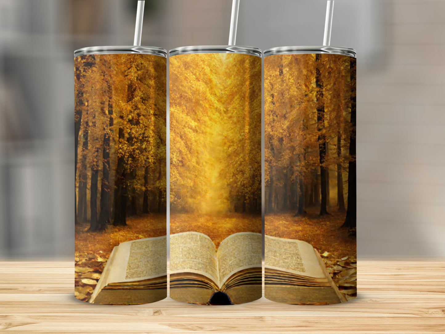 Three tumblers with open book and autumn forest scene.