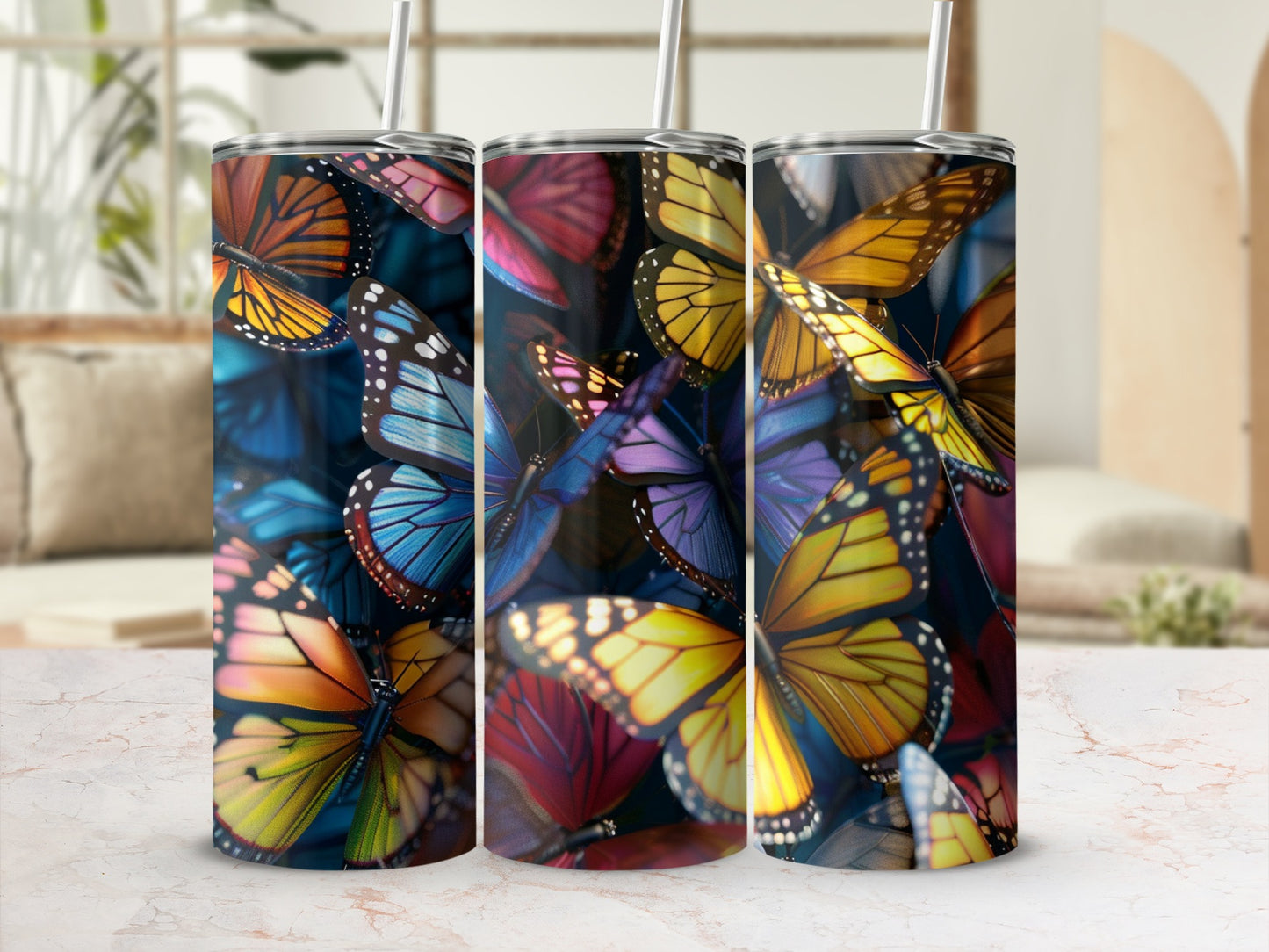 Three tumblers adorned with colorful butterfly patterns sit on a marble surface.