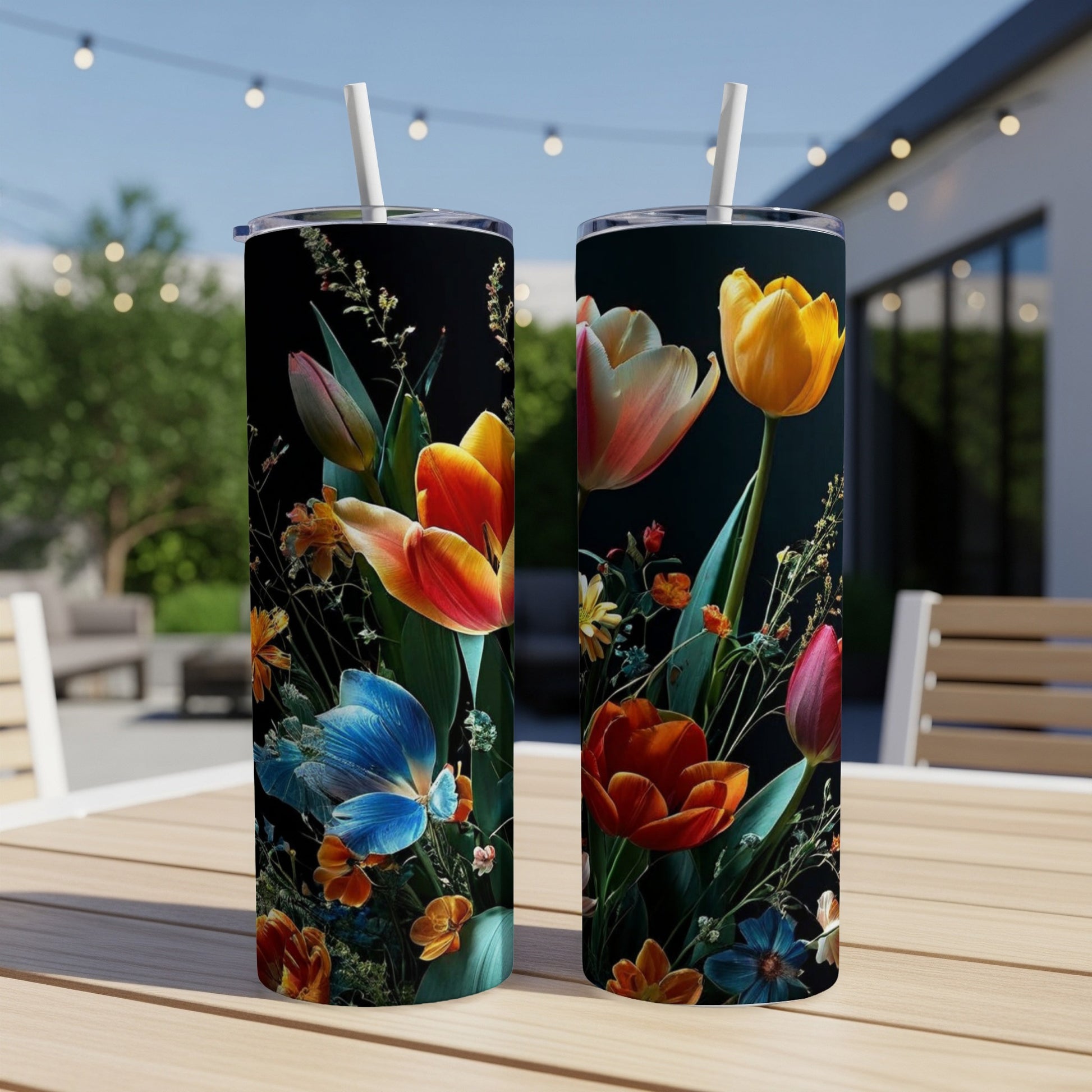 Two tumblers with a vibrant floral and butterfly design on a dark background.