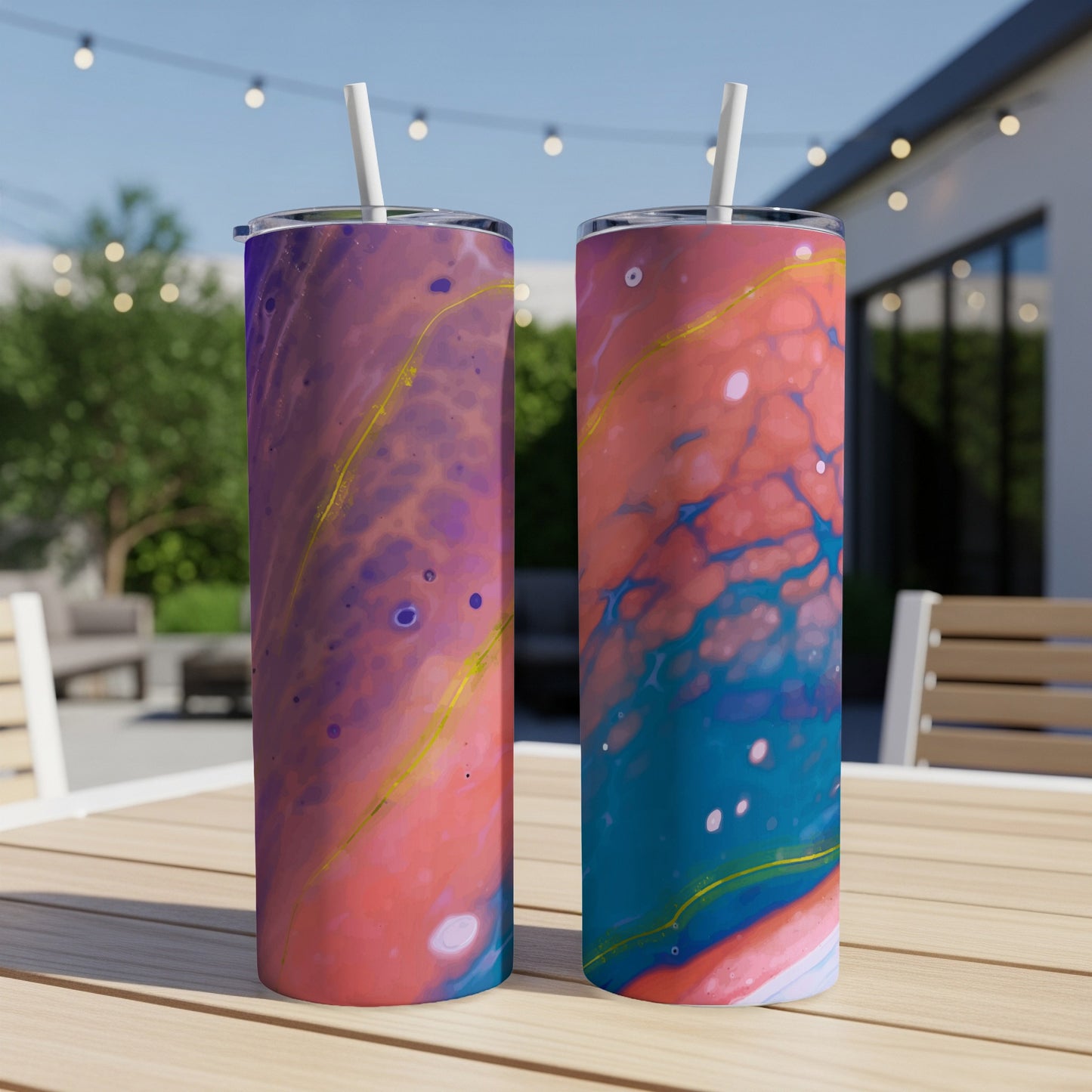 Two tumblers with marbled purple and pink designs with gold accents stand on a table.
