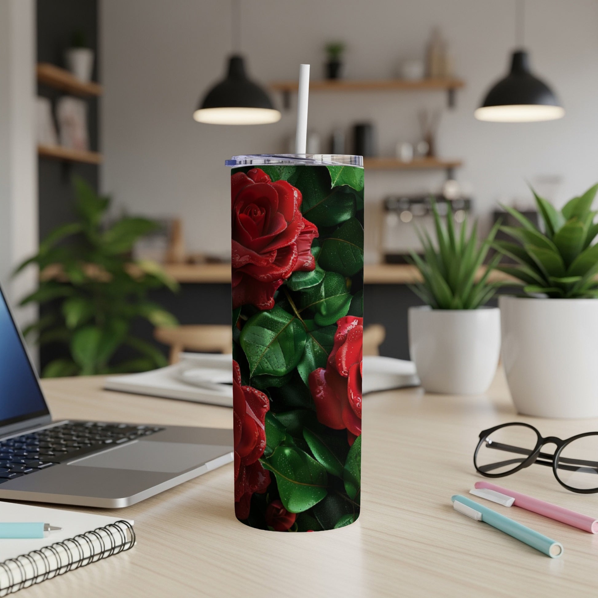 Red roses and green leaves design on a tumbler with a white straw.