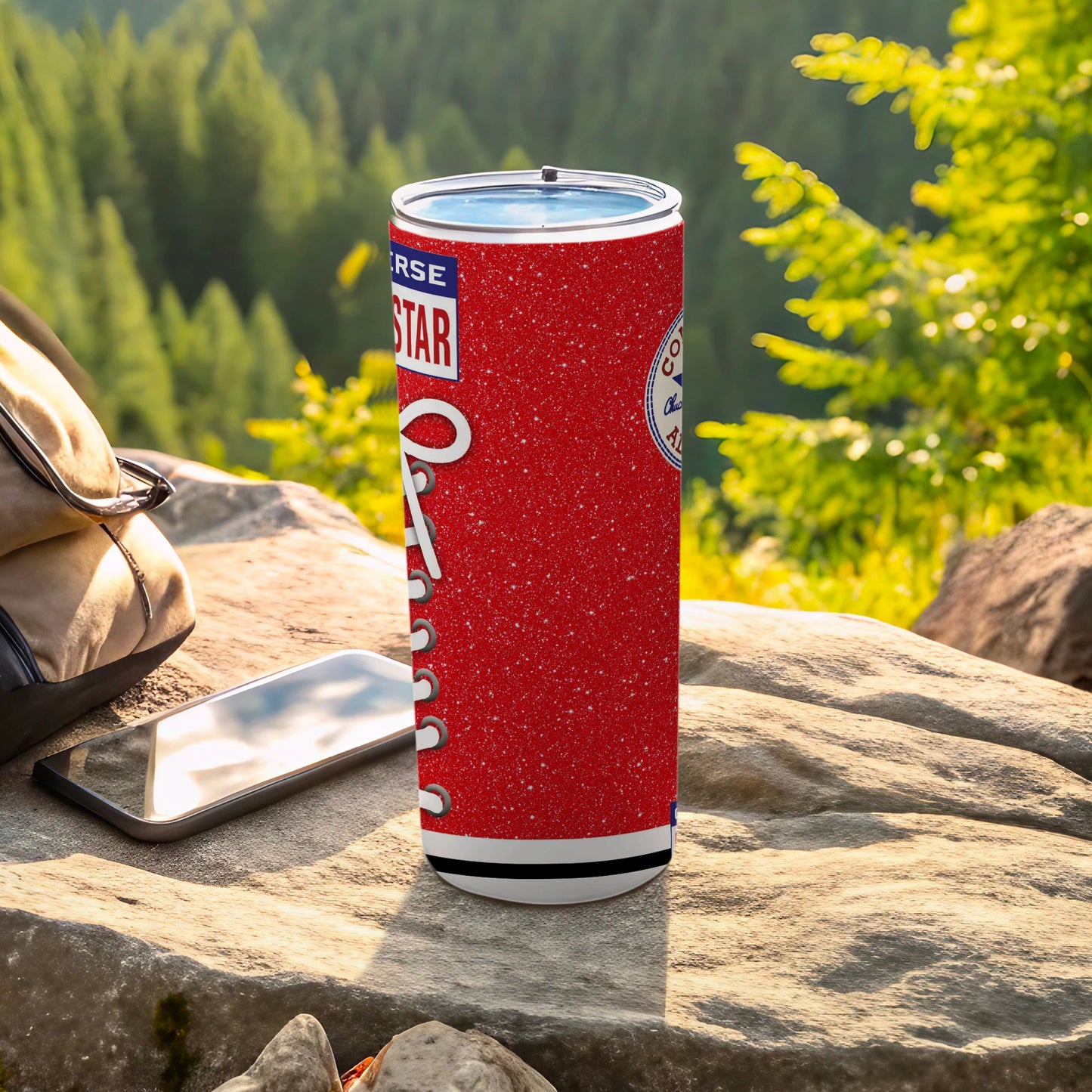Red Converse all-star tumbler with white laces design on a rock.
