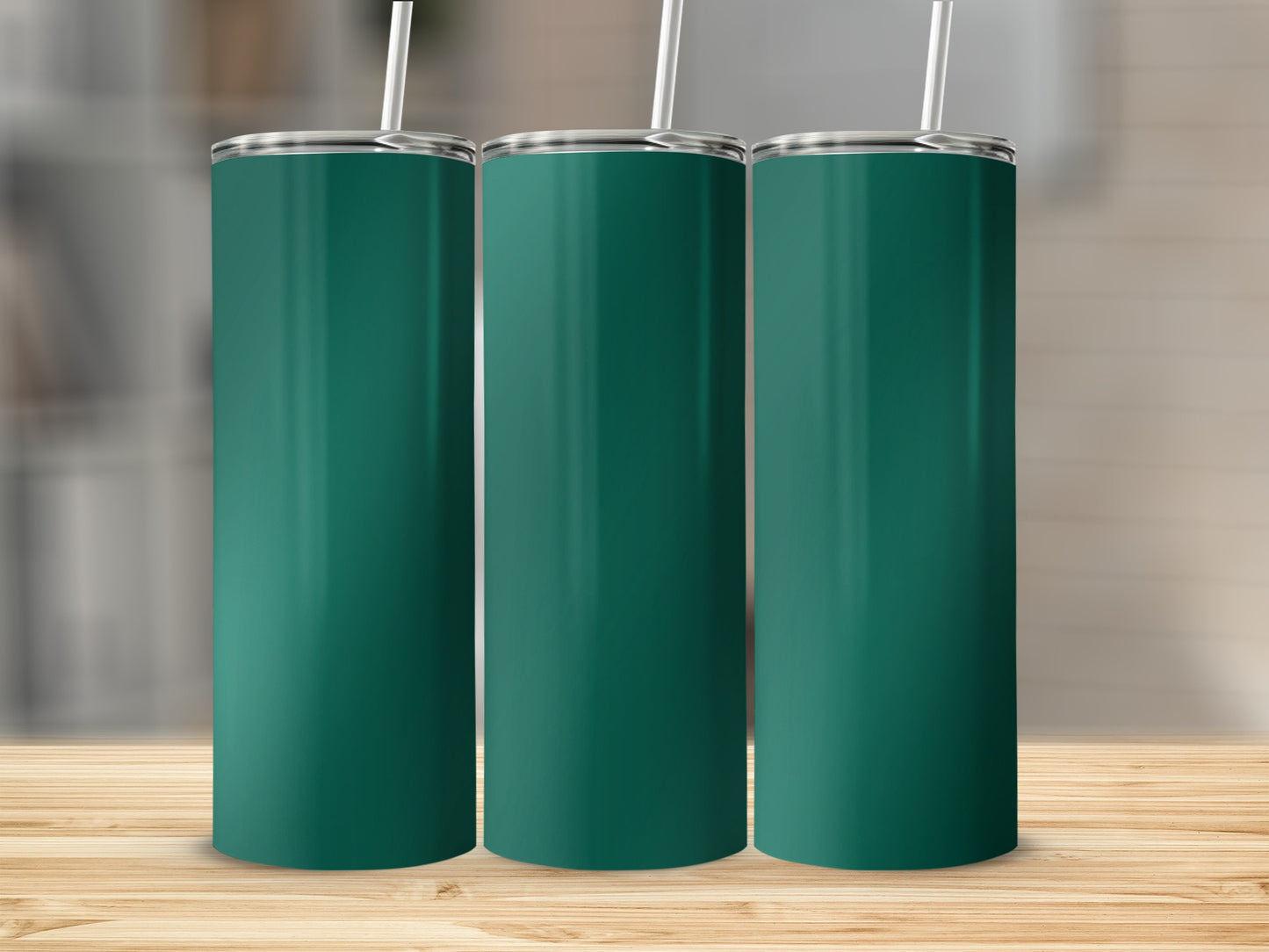 Three teal colored tumblers with white straws stand on a wooden surface.