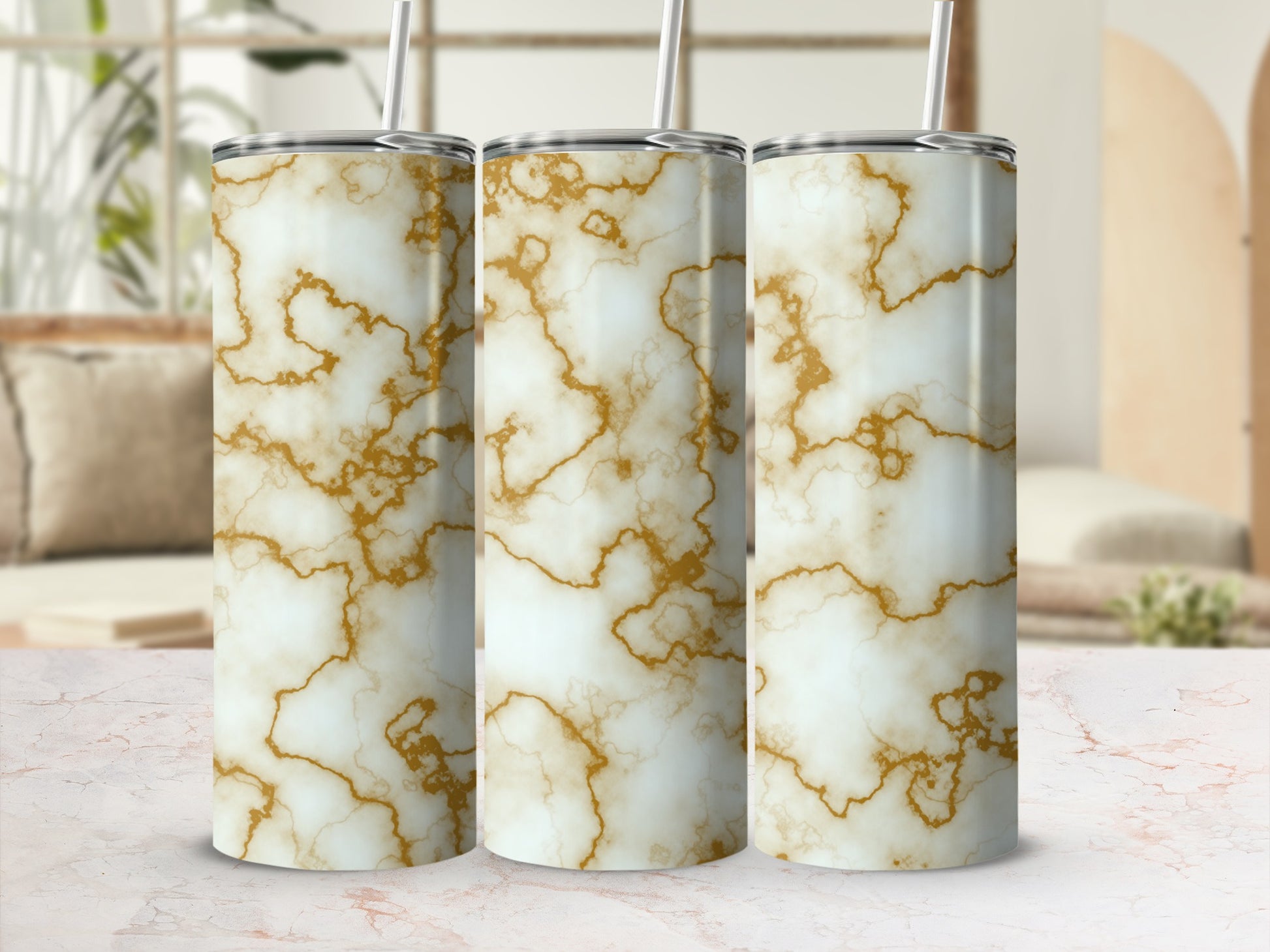Three white marble tumblers with gold veining and straws on a marble surface.