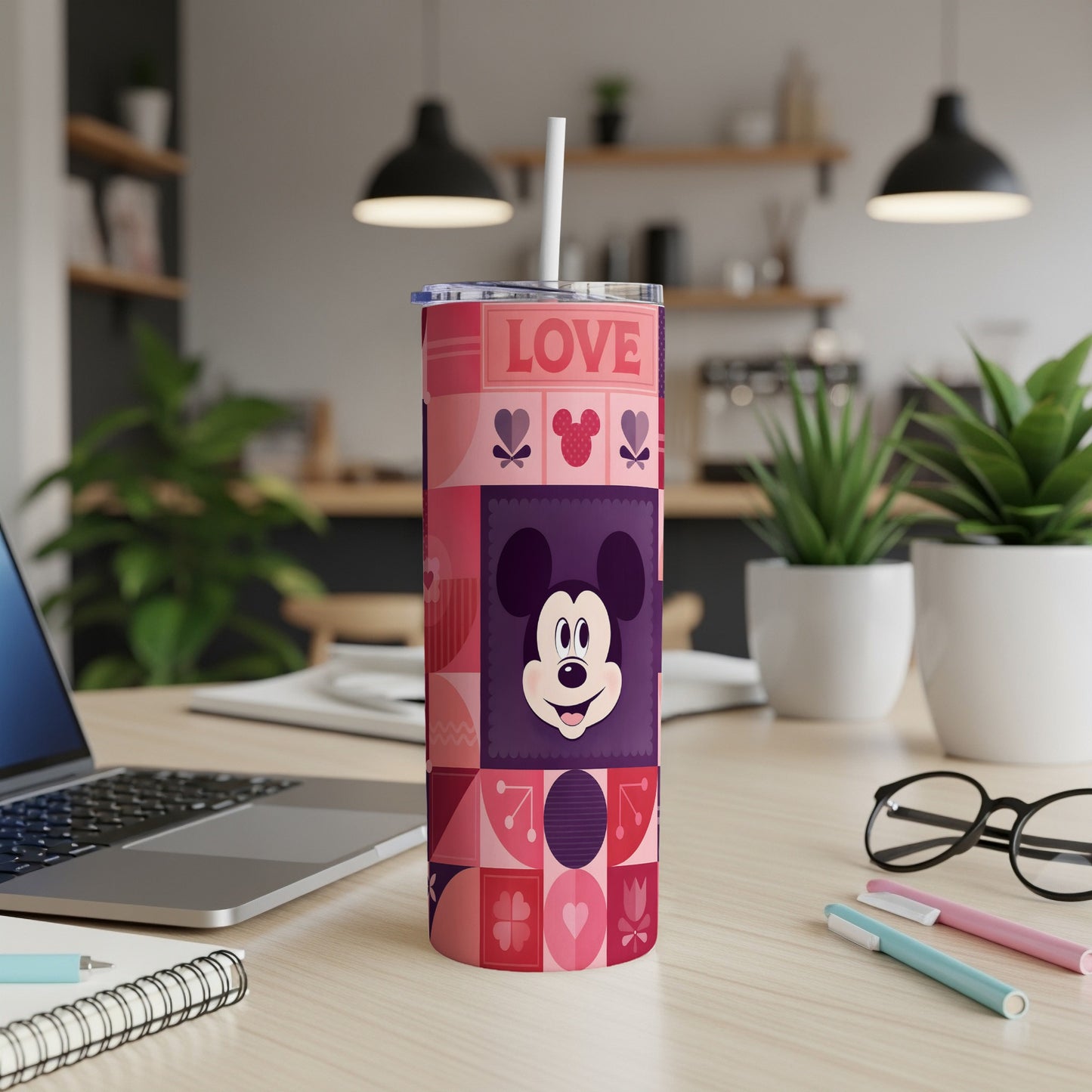Mickey Mouse heart pattern tumbler with straw on a desk.