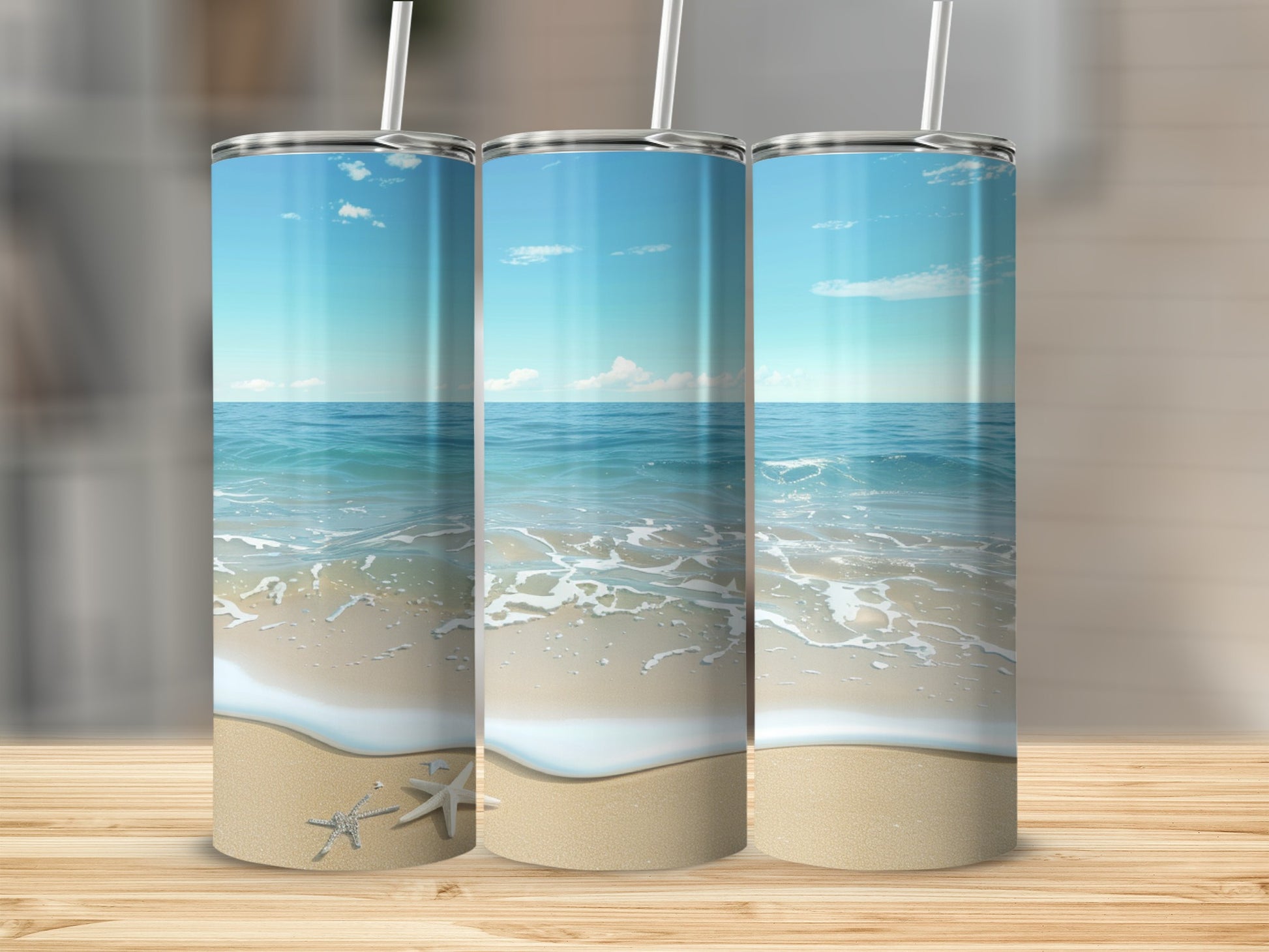 Three tumblers with beach scene design, white straws.
