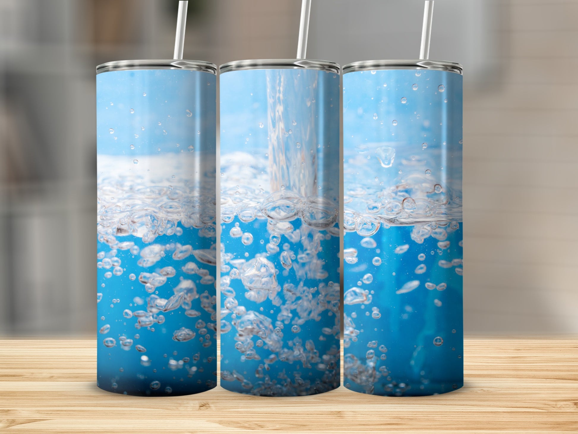 Three tumblers with water splashing and bubbles against a blue background.