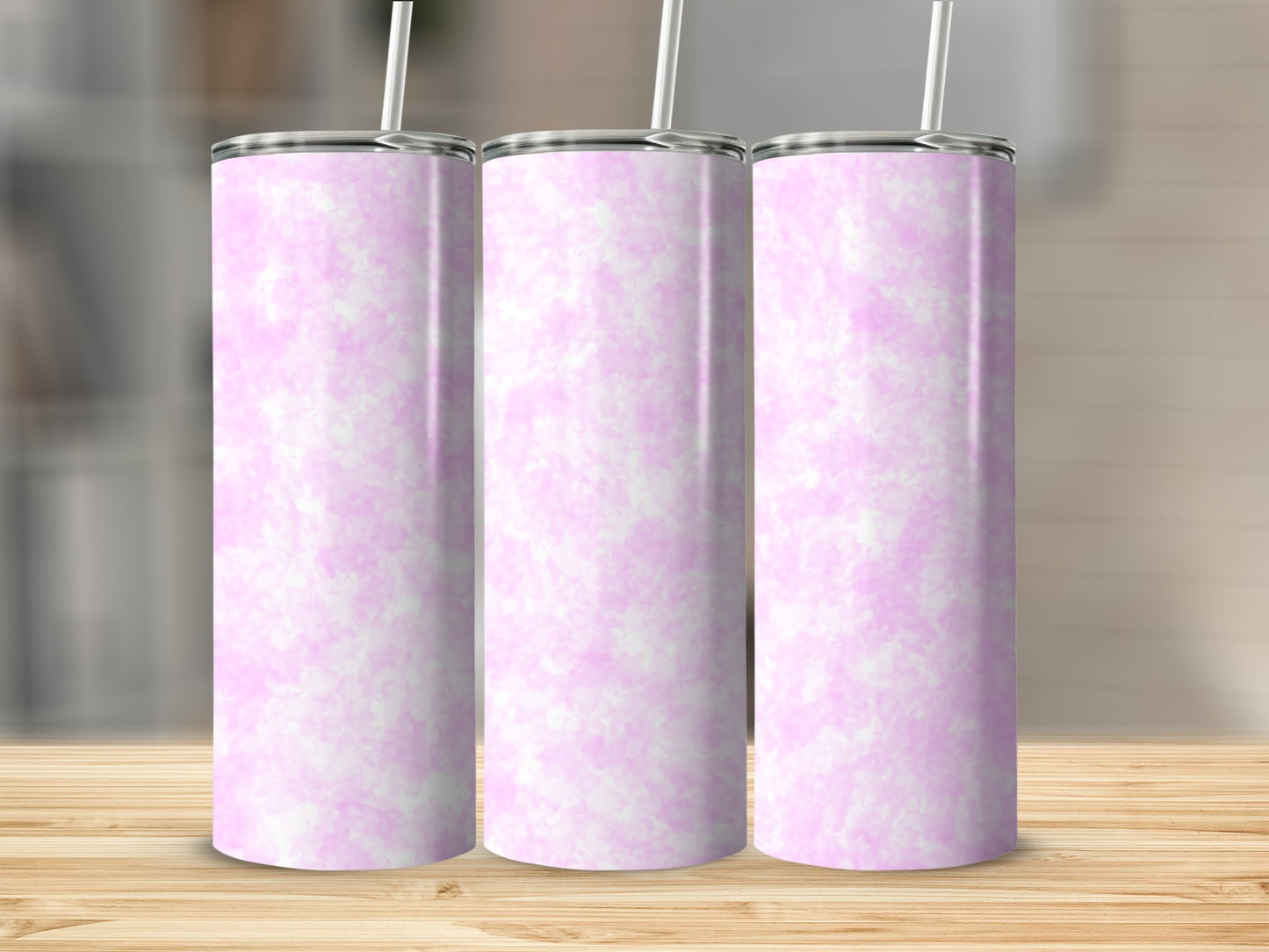 Three pink and white marbled tumblers with straws on a wooden surface.