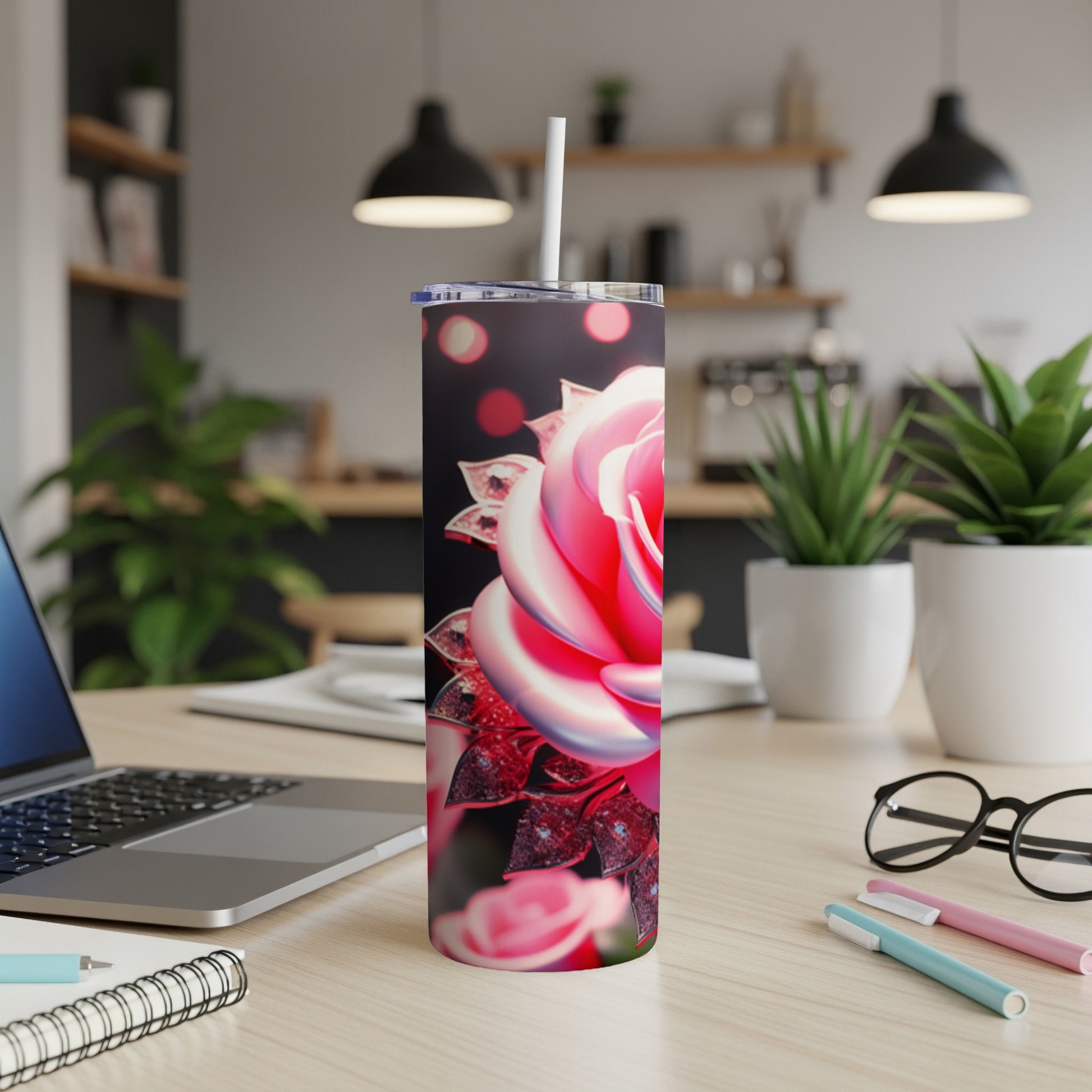 Pink rose on a tumbler with a bokeh background and office desk items.
