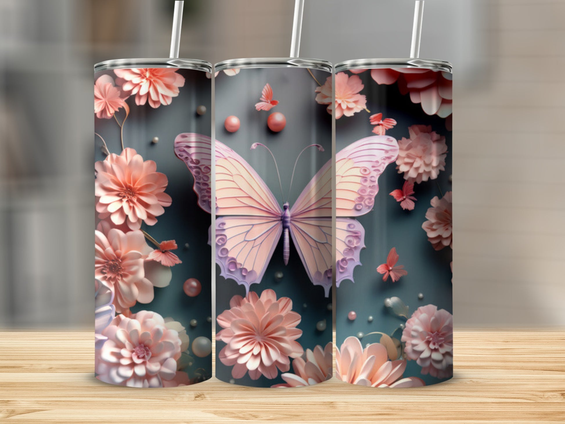 Three pink floral tumblers with butterflies, displayed on a wooden surface.