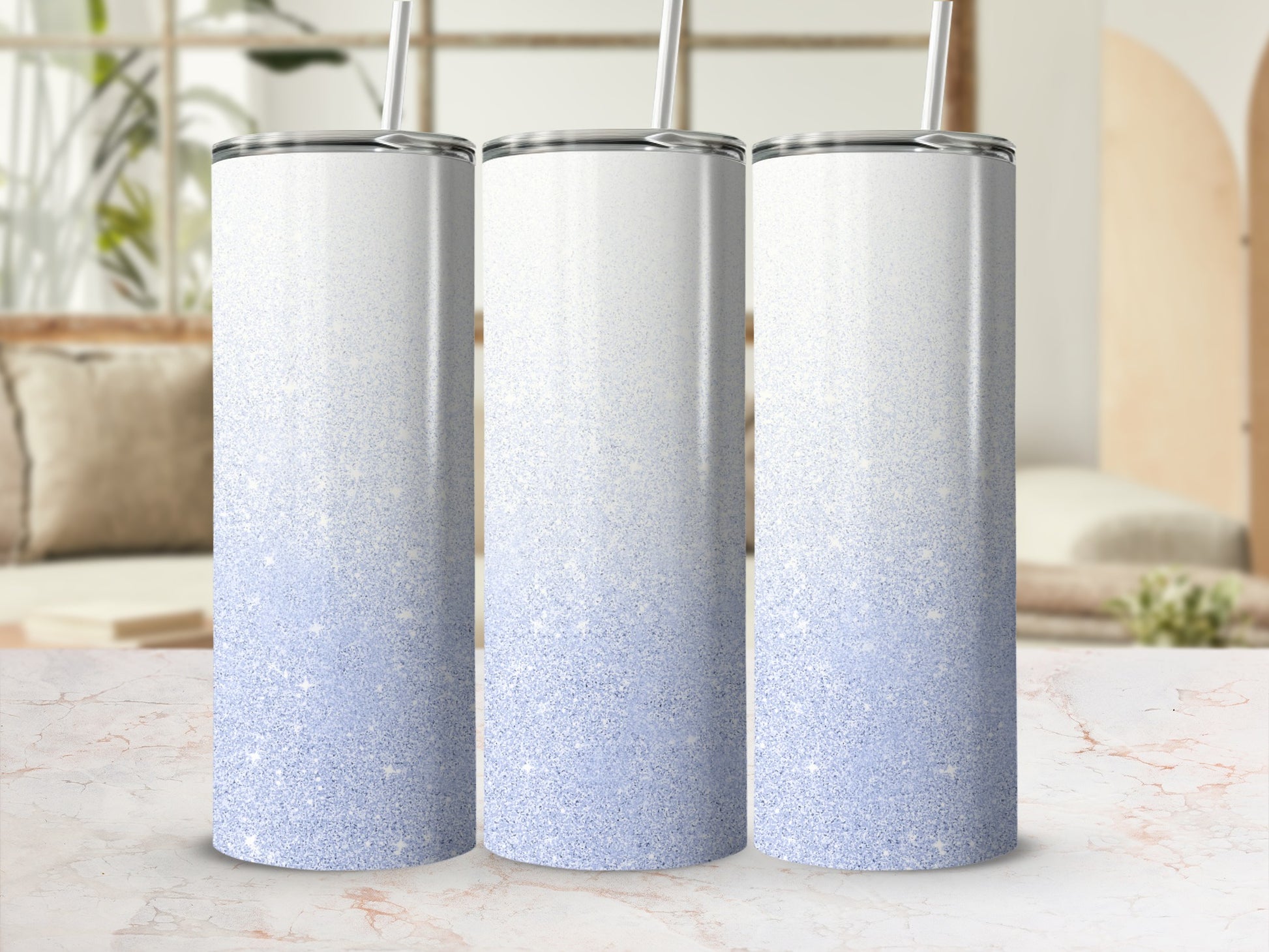 Three silver tumblers with blue glitter gradient and straws.