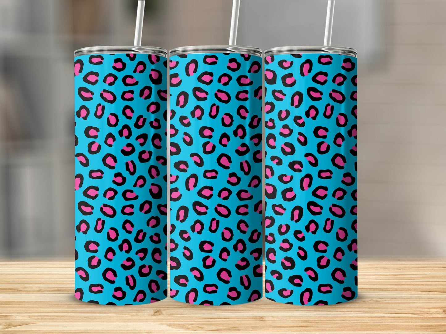 Three tall tumblers with a bright blue and pink leopard print pattern.