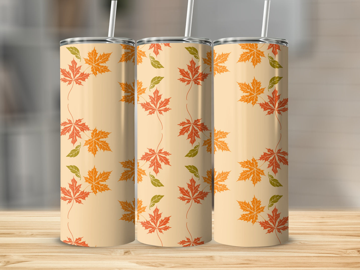 Three tumblers with an autumn leaf pattern on a wooden surface.