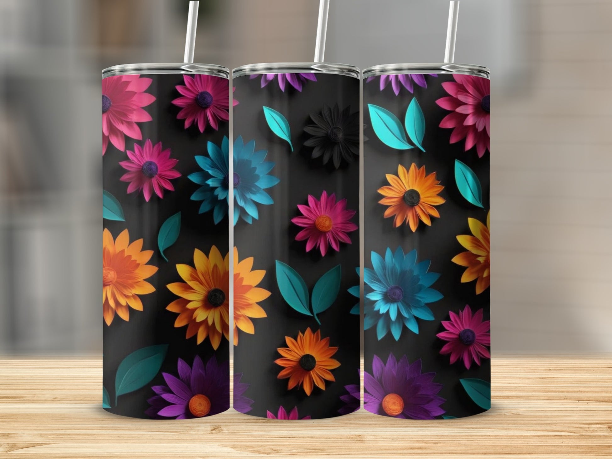 Three tumblers with colorful floral designs on a black background.