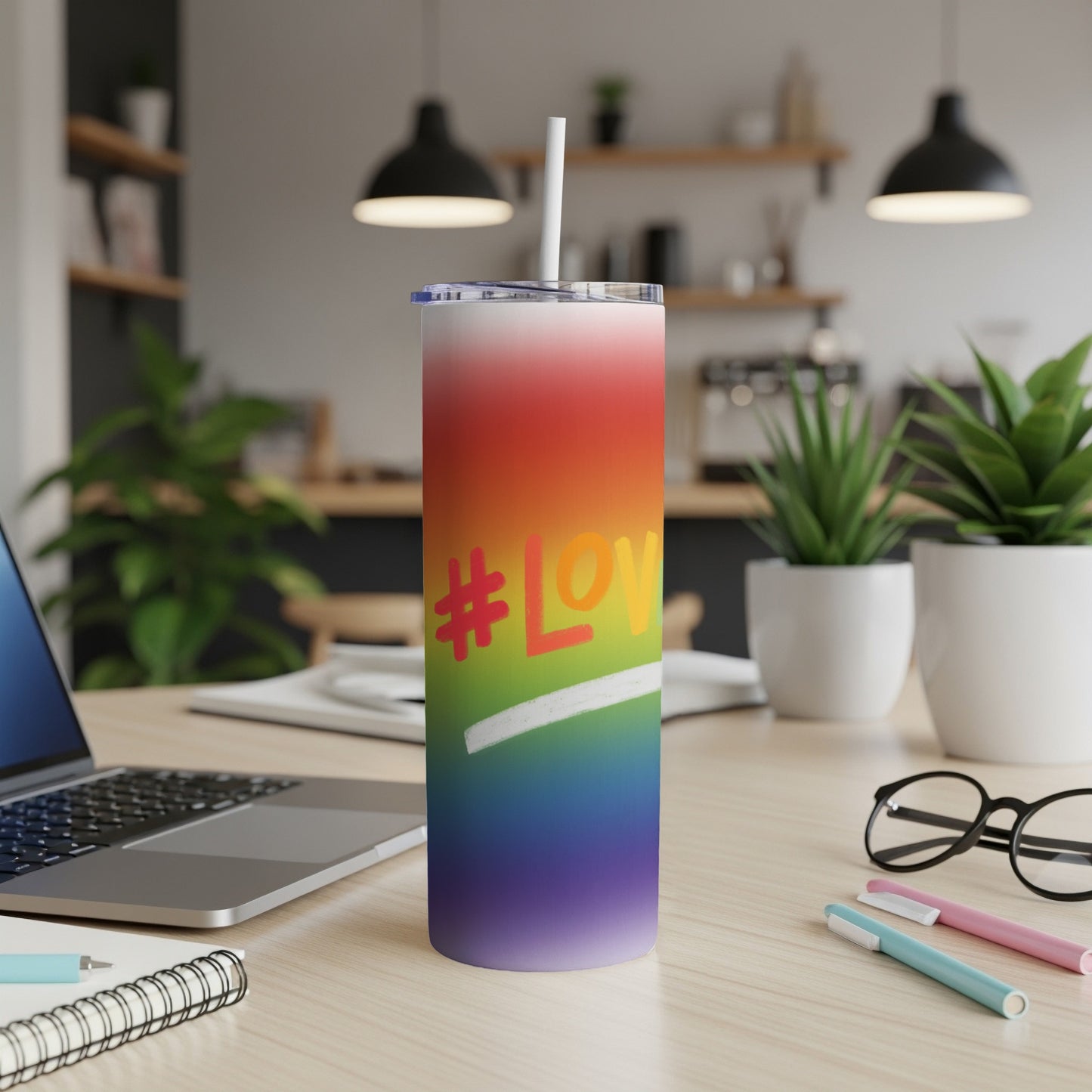 Rainbow gradient tumbler with "#Love" text and straw on a desk.