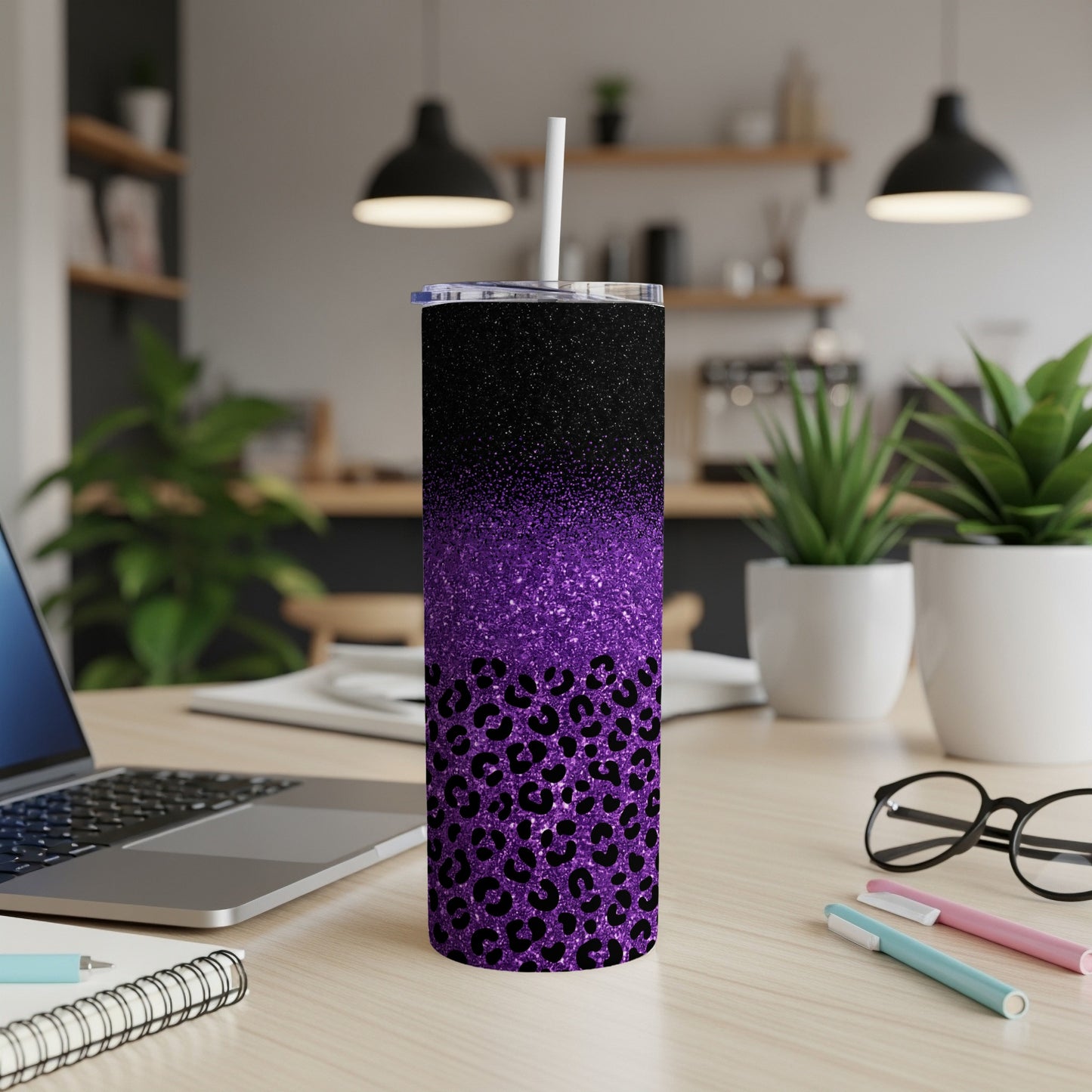 Purple glitter leopard print tumbler with straw on desk.