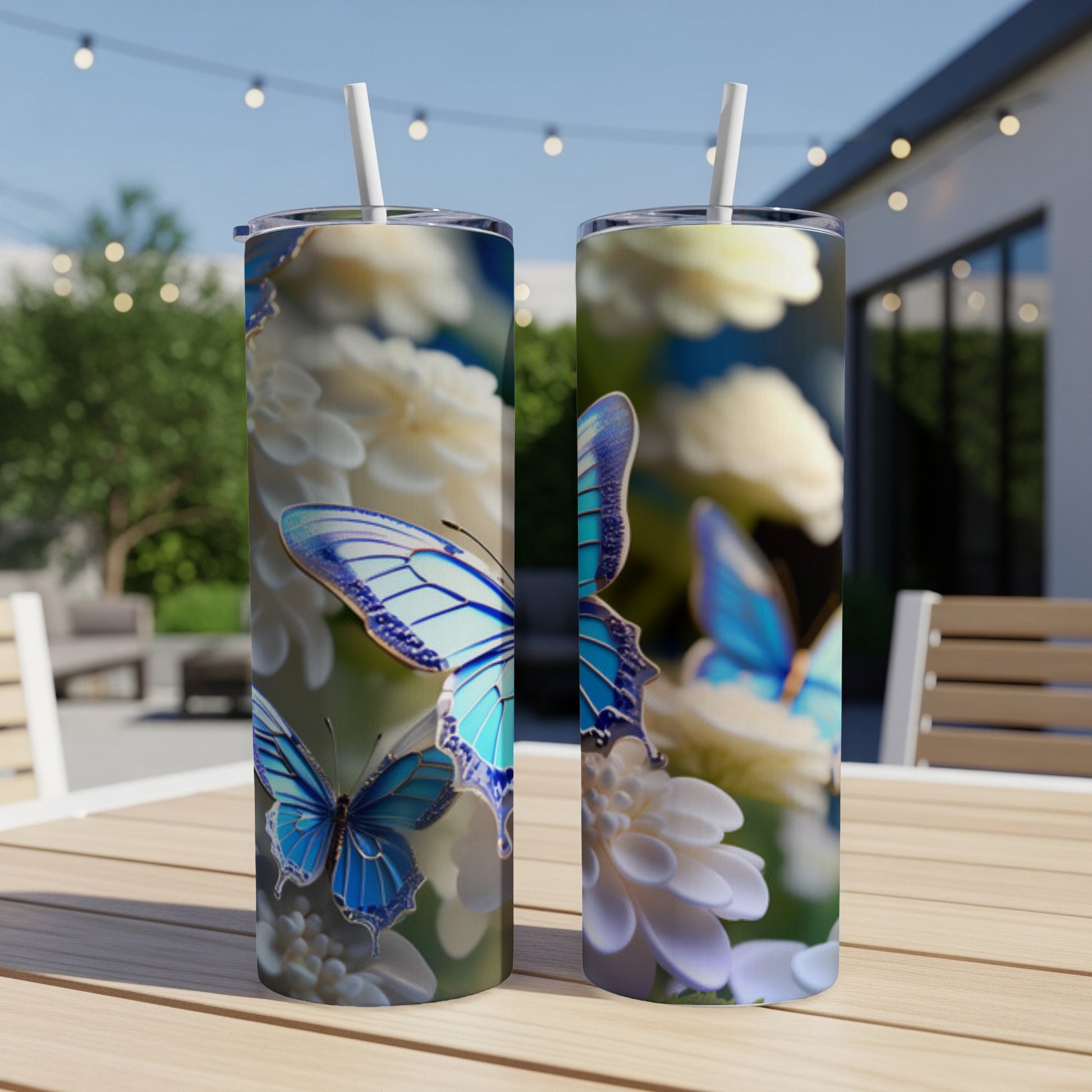 Two blue butterflies on white flowers adorn clear tumblers with straws.