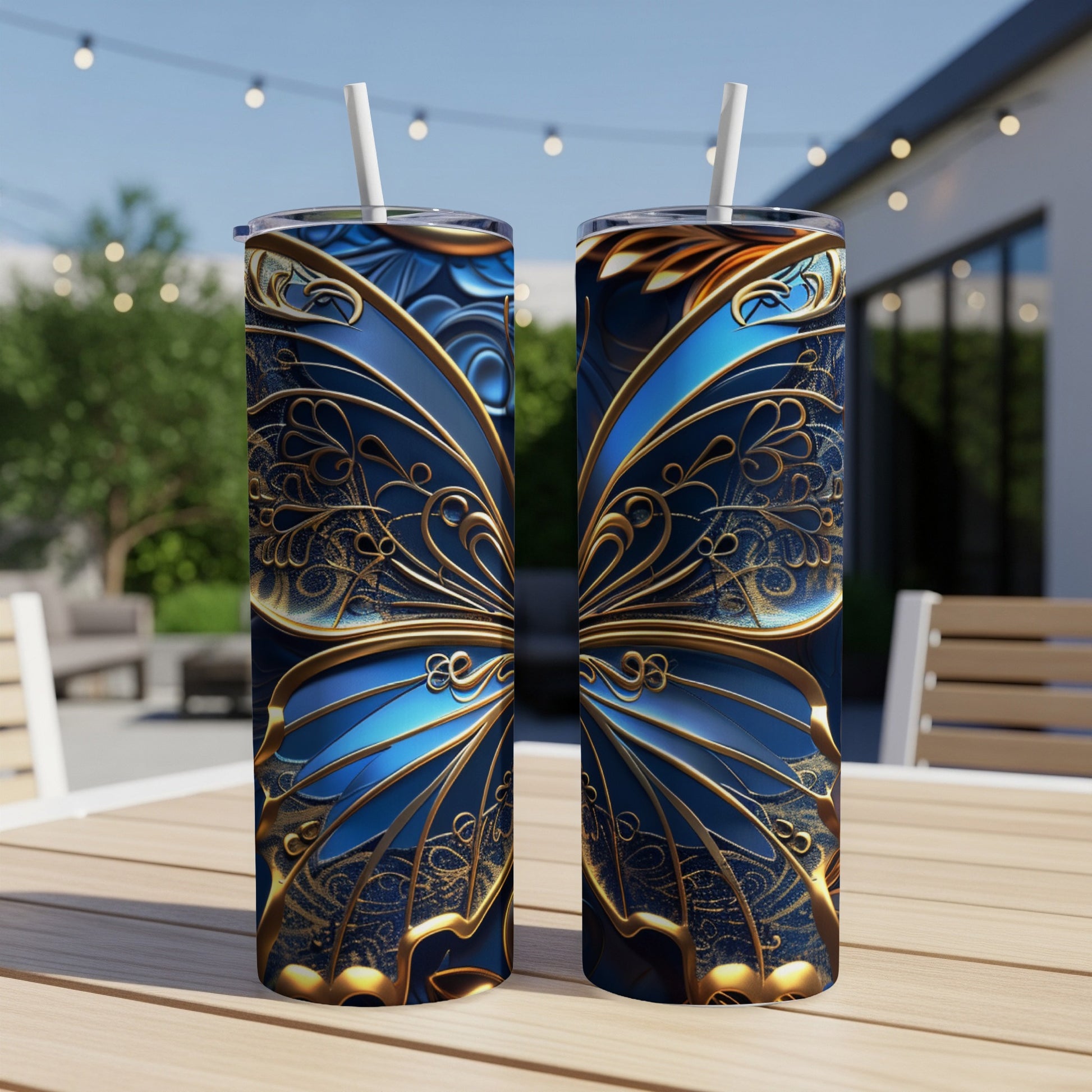 Two tall blue tumblers with ornate gold butterfly wing designs on a wooden table.