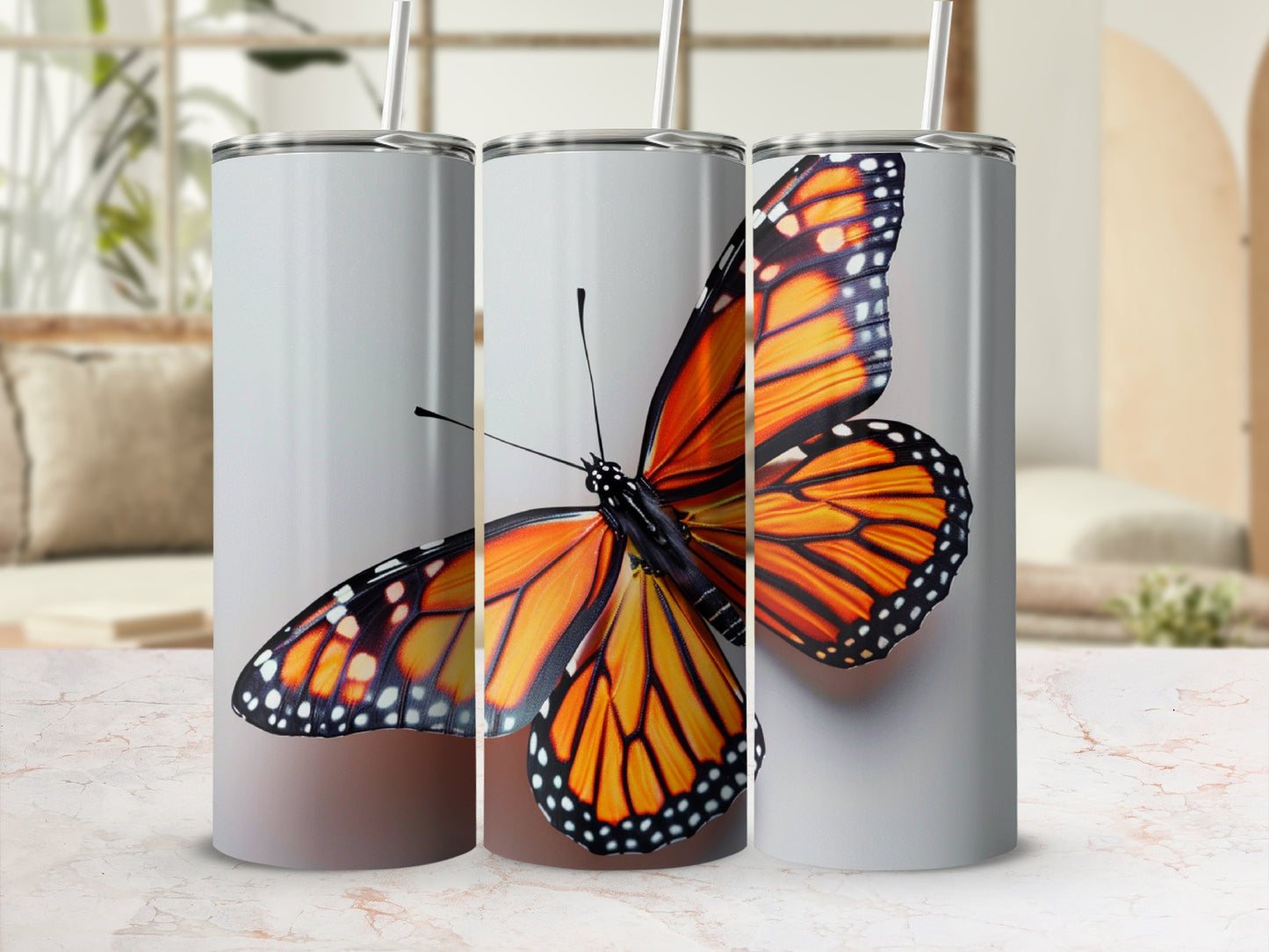 Three tumblers featuring an orange monarch butterfly illustration.
