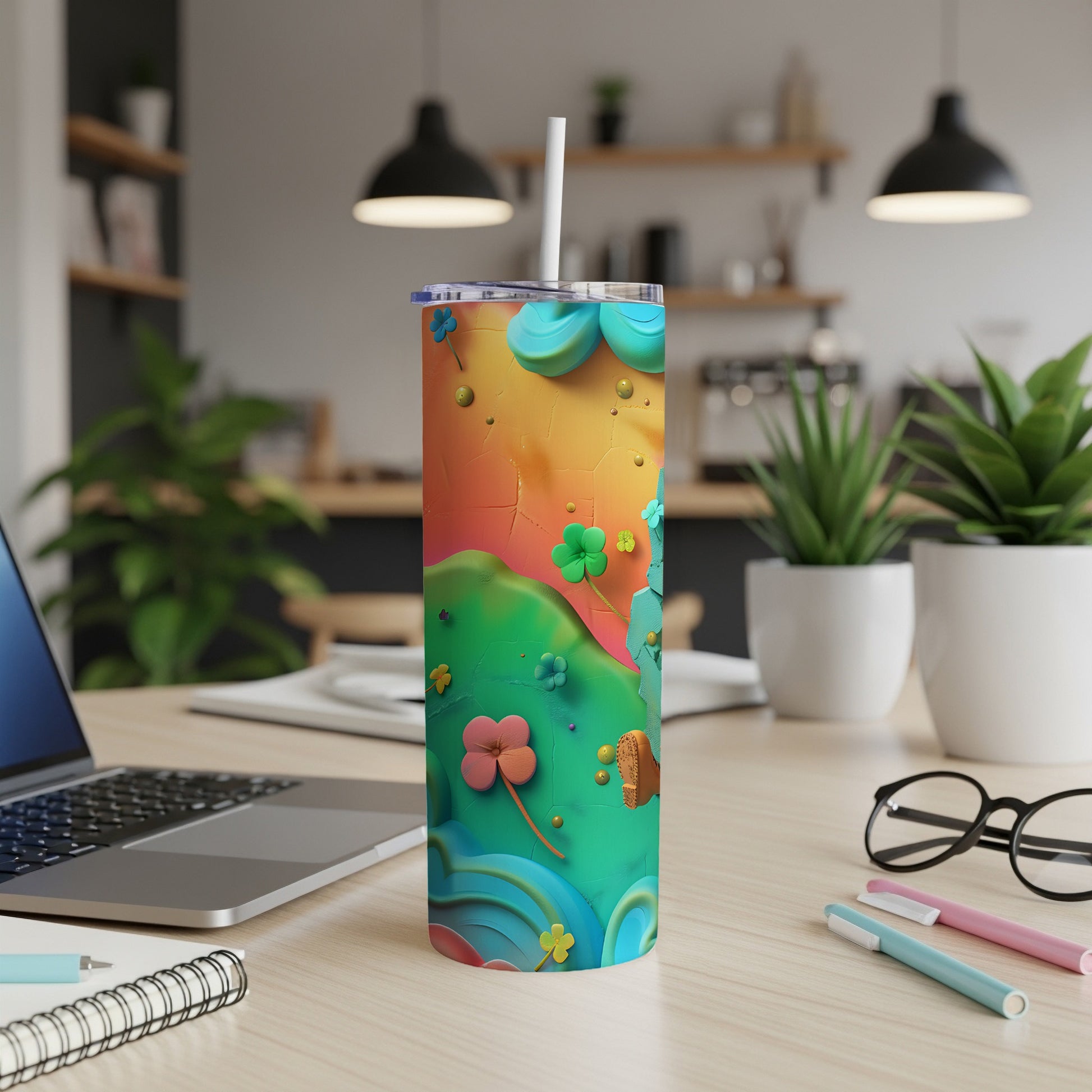 Colorful tumbler with floral and clover designs on a desk.