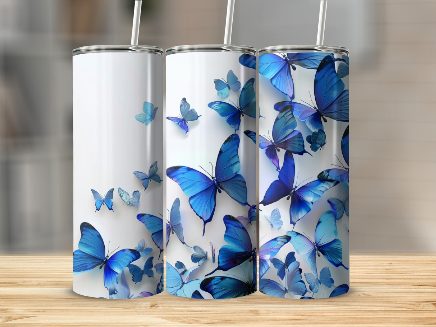 Three white tumblers with blue butterflies, standing on a wooden surface.