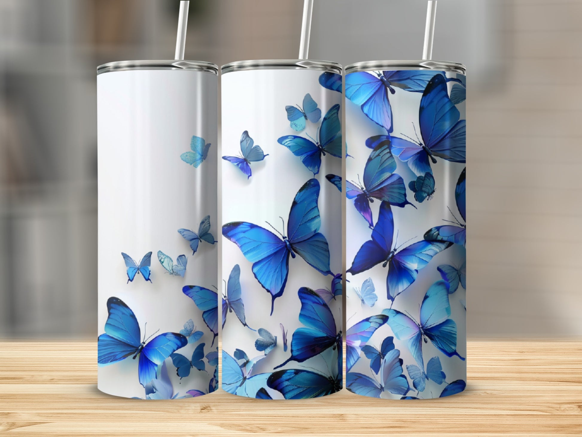 Three white tumblers with blue butterflies, standing on a wooden surface.