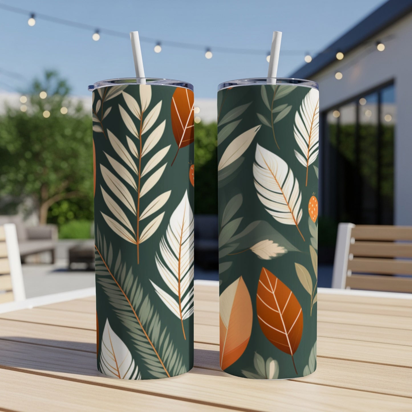 Two tumblers with a dark green background and cream, rust, and orange leaf and feather pattern.